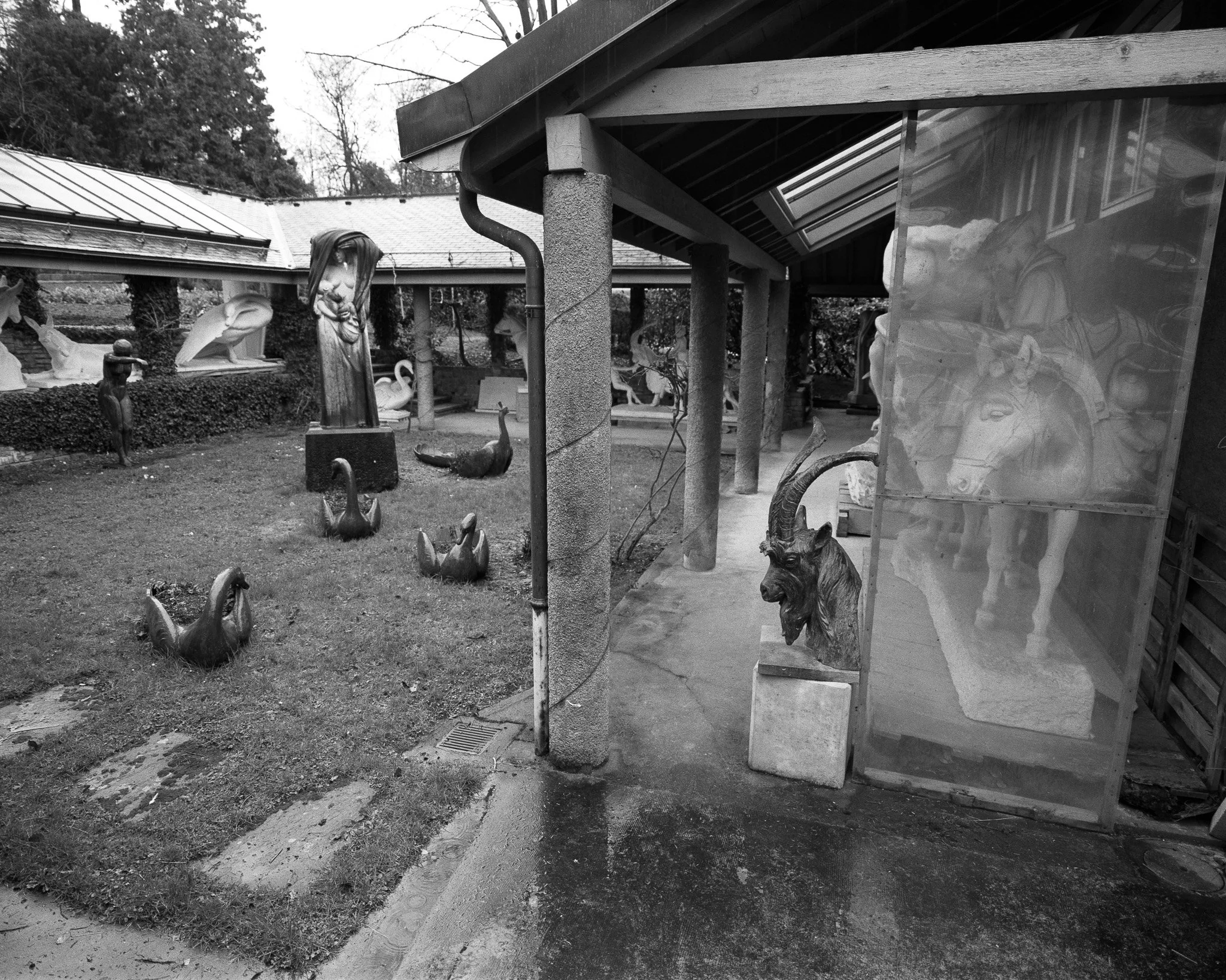 Black-and-white street photograph of a courtyard filled with sculpture, Lausanne.