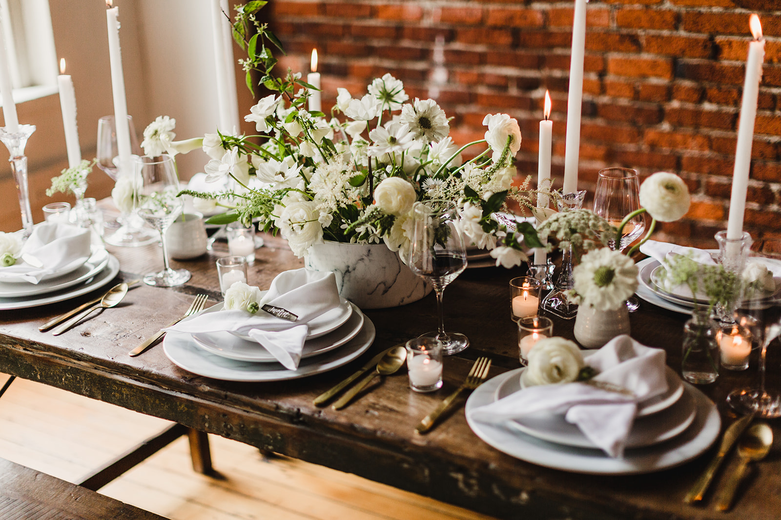A far from boring decadent white color scheme on our farm tables. Our marble chargers add that touch of modern elagance. Photography Lady J Memories , styling by Swoon Event and Design , florals by The Bend Flower Company , rentals by Curated .