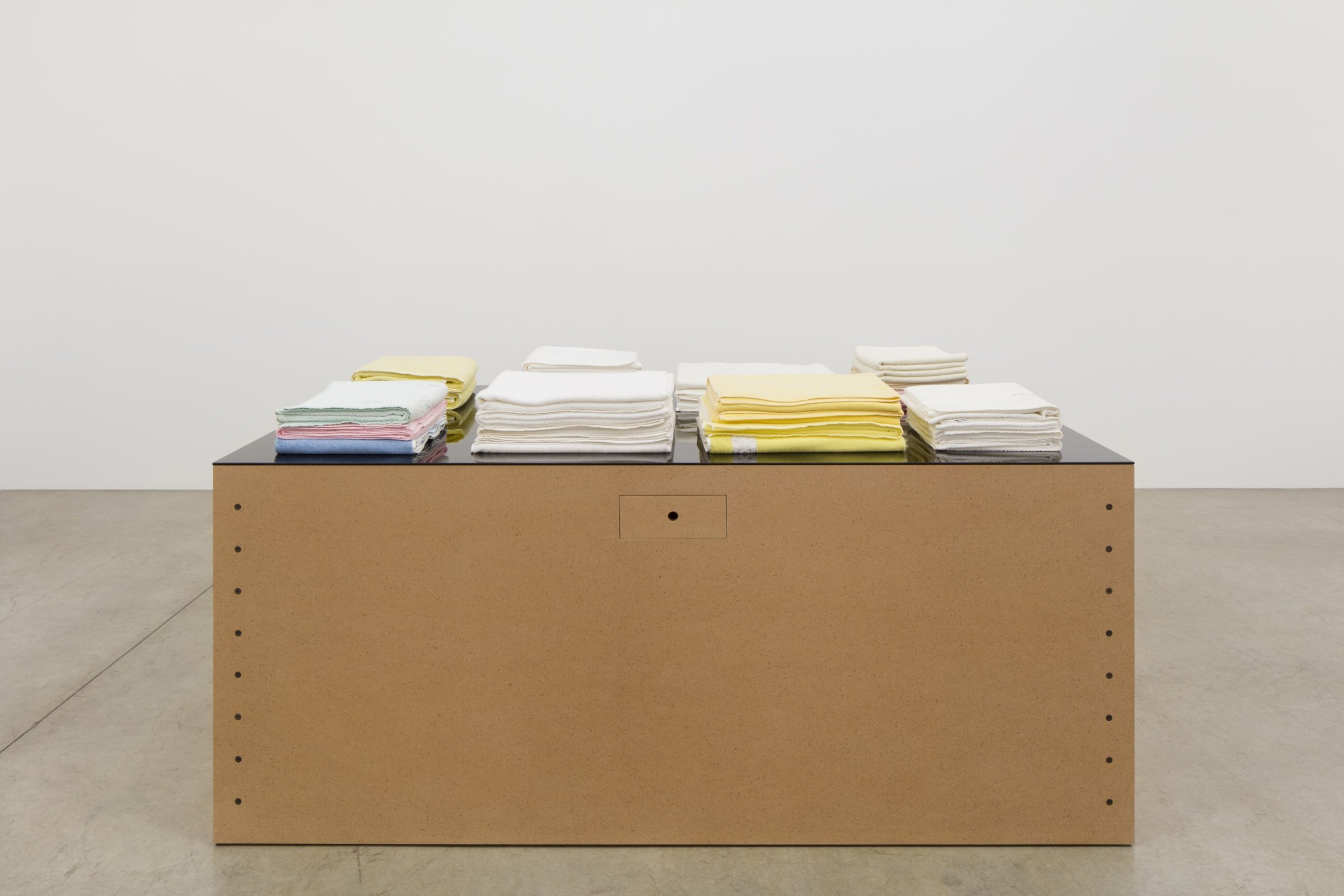  Haim Steinbach   Untitled (table with towels, bone, pacifier) , 1993 Medium density fiberboard table with glass top; cotton towels; plastic and rubber pacifier; rawhide bone 35 1/2 x 86 1/2 x 45 1/4 inches; 90 x 220 x 115 cm (TBG 13715) Courtesy of 