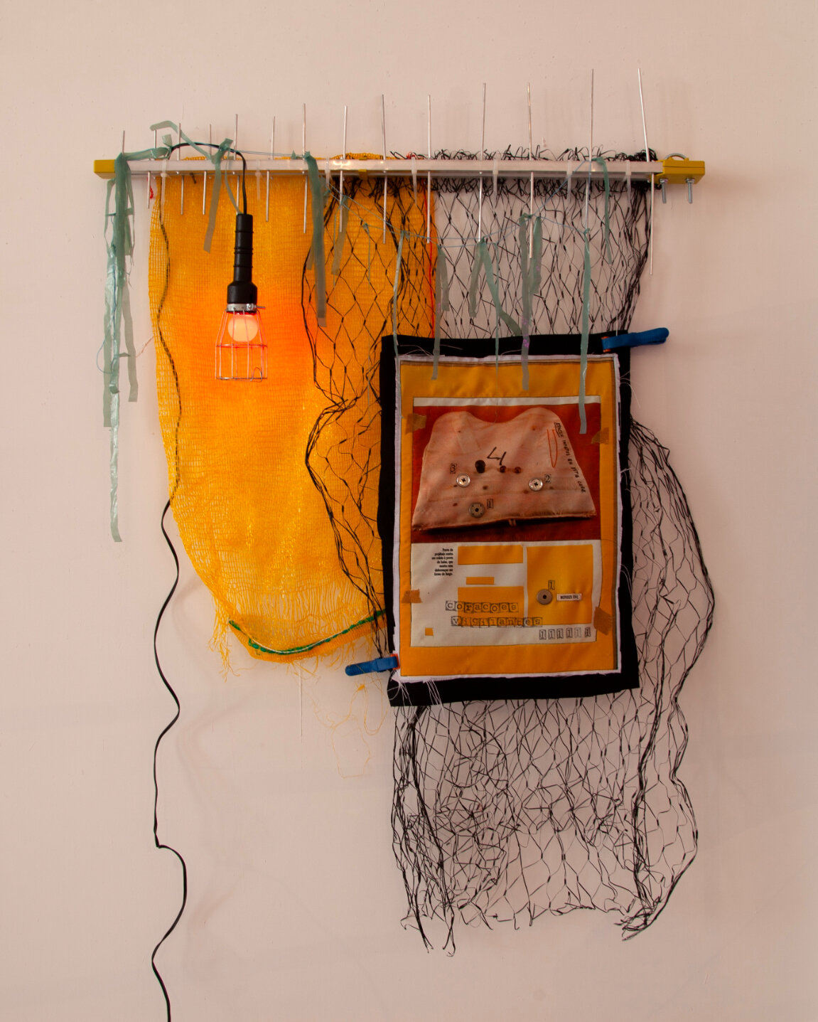  Randolpho Lamonier&nbsp;  Corações vigilantes (Vigilant hearts) , 2021&nbsp; Mixed media (Photo print, painting and buttons on fabric, plastic, metal net, light fixture and tv antenna)&nbsp; 51 x 39.5 x 4 in.&nbsp; RL007     