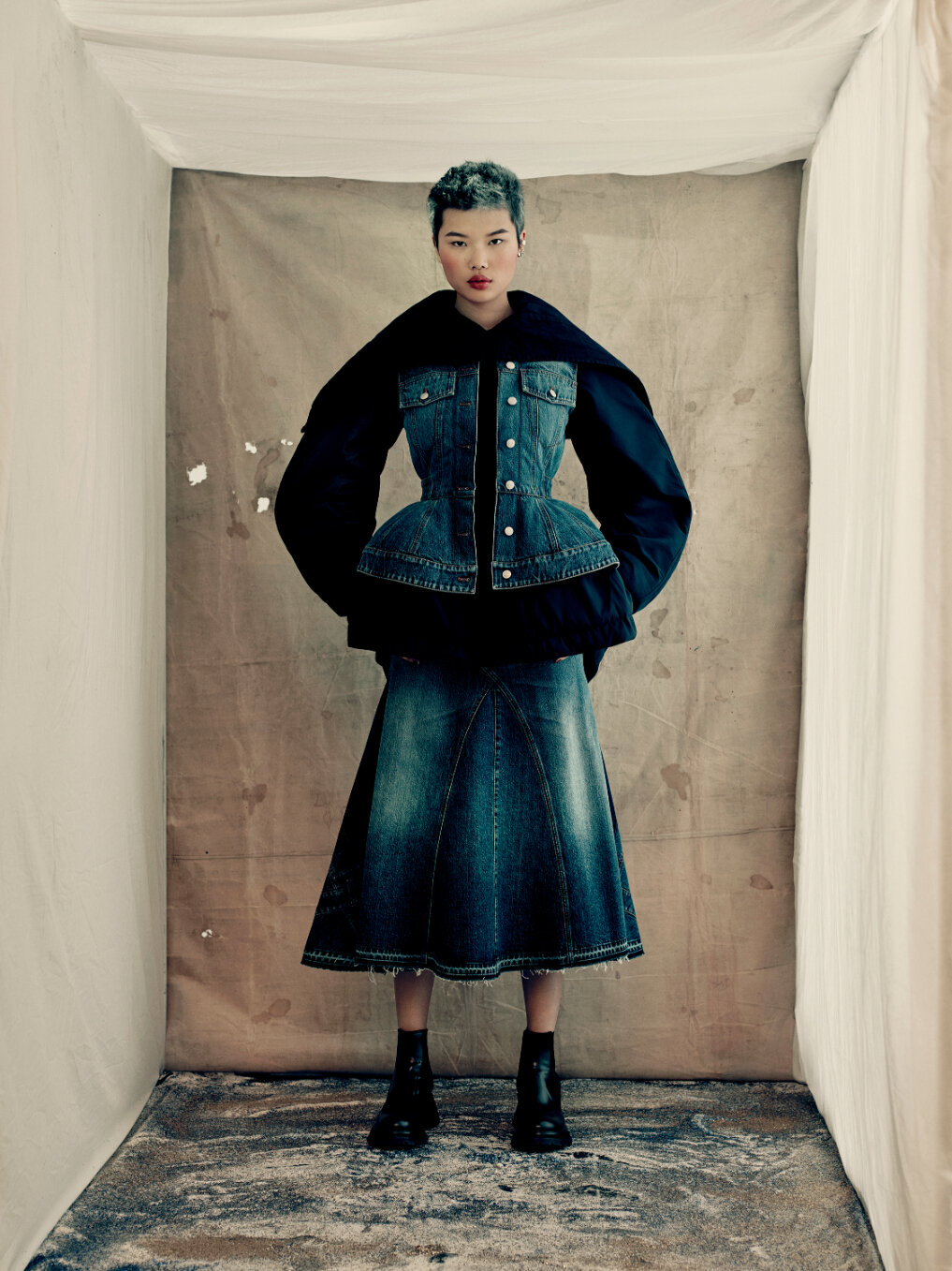  A parka jacket with an exploded hood and sleeves in navy poly faille and lake blue washed denim and a fluted panelled skirt in lake blue washed denim.  