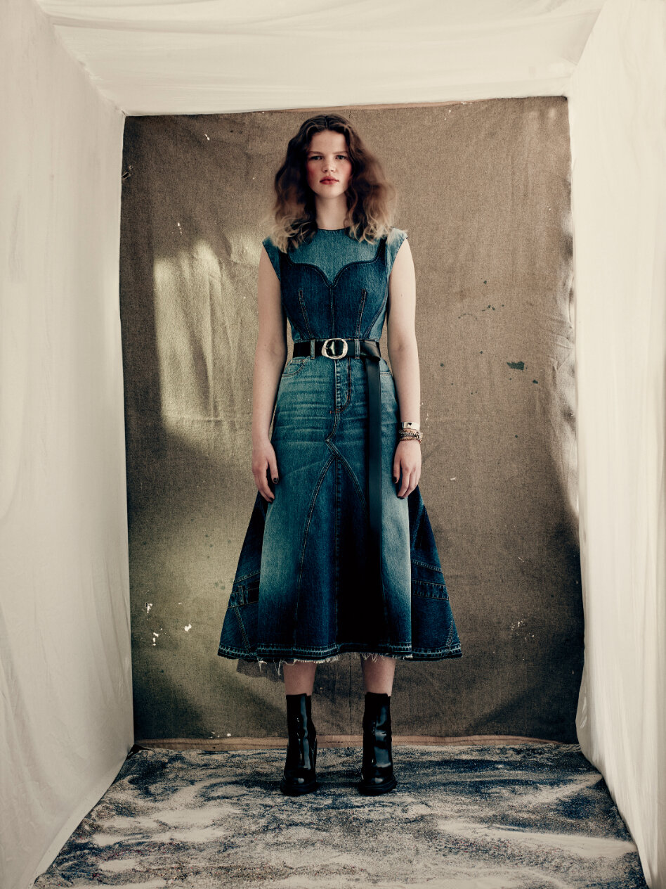  A pieced and reconstructed dress with a shadow wash bodice and fluted panelled skirt in lake blue washed denim.  