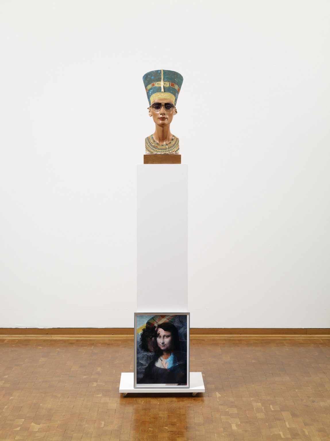  Isa Genzken  Nofretete – Das Original  (2012) Nefertiti plaster bust with sunglasses on wooden base, wooden plinth and colour photograph in aluminium frame 184 x 50.5 x 40 cm Courtesy Galerie Buchholz/VG Bild-Kunst, Bonn 2023 Photo: Sascha Fuis  