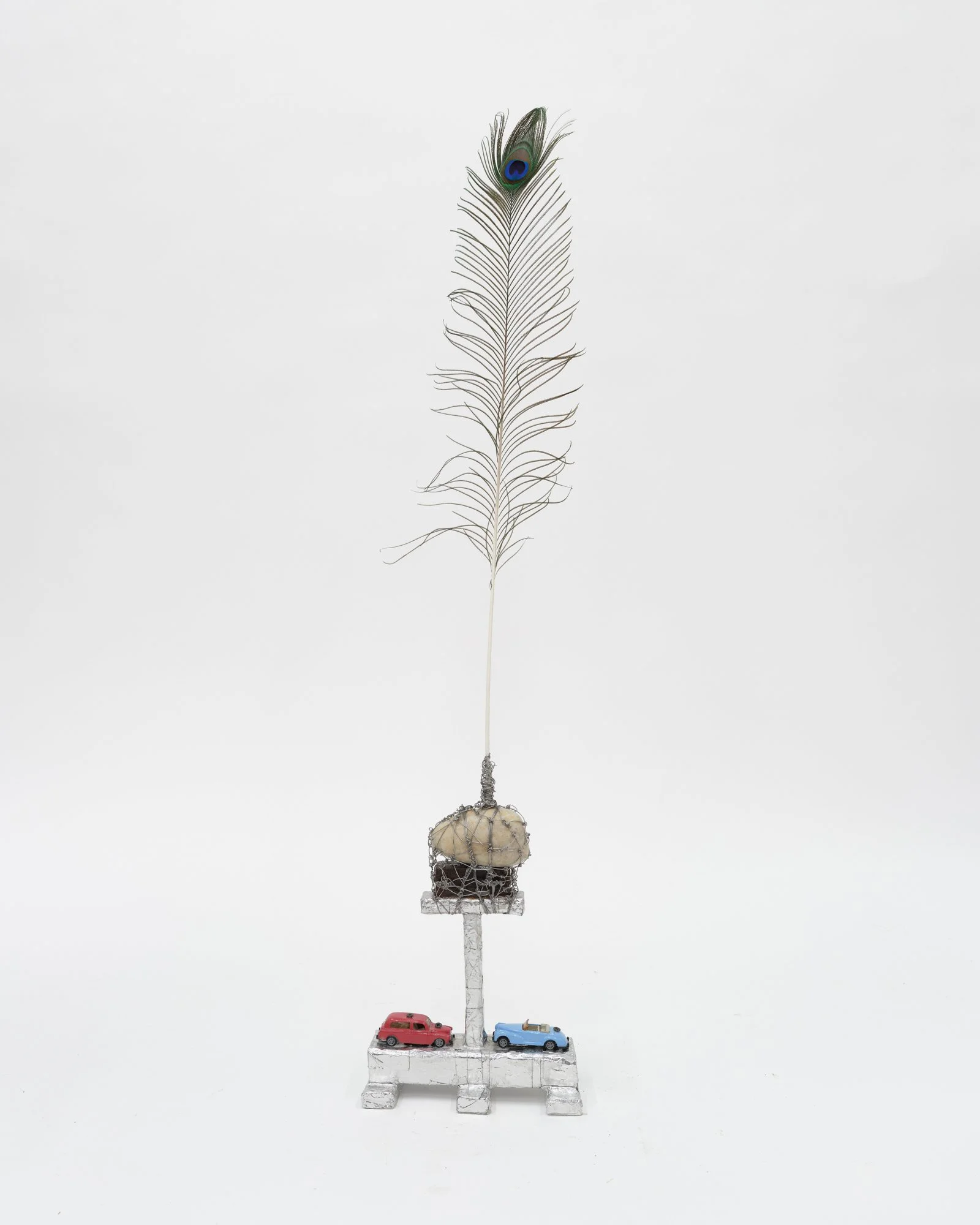  Arthur Simms  Monument to the Lighthouse , 2024 Feather, wire, stone, metal, tin foil, toy cars, screws, wood, and glue 44 × 9 5/8 × 5 in.  © Arthur Simms. Courtesy the artist and Karma 