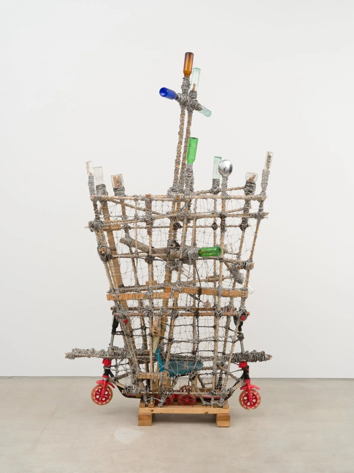  Arthur Simms  Dreamcatcher IV , 2017 Wire, bottles, scooters, wood, bamboo, chair, metal, stone, and feather 99 × 60 × 35 in. © Arthur Simms. Courtesy the artist and Karma 
