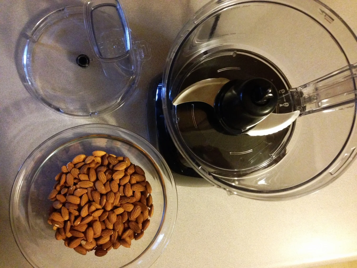 Food processer and almonds for making homemade healthy nut butter - health food how-to!