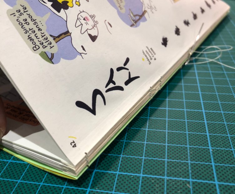 Le dos du livre pendant la couture en cours de la réalisation