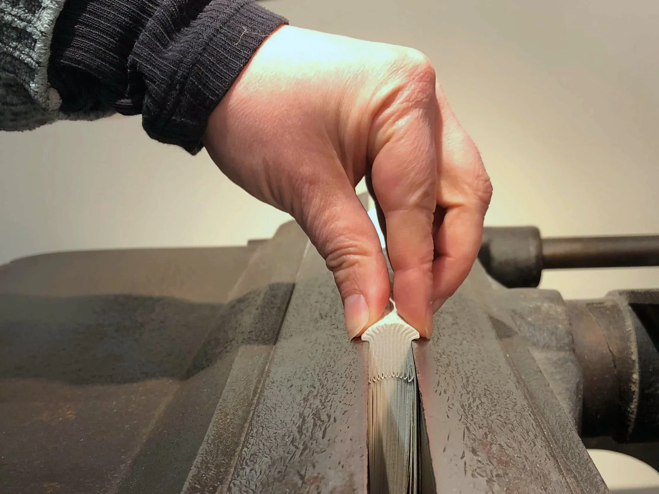 Vue sur la main d'Héléna Frere appuyée sur l'extérmité d'un dos en cours d'endossure dans l'étau