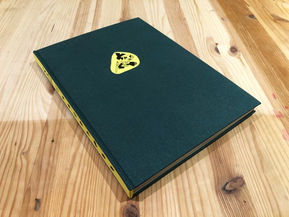 Bradel à dos droit en toile avec impressions sur papier jaune collée sur le dos et sur le plat