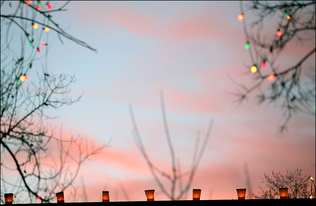 Rick Scibelli Jr. for The New York Times Farolitos, also called luminaries, compete with the setting sun in Santa Fe, N.M.