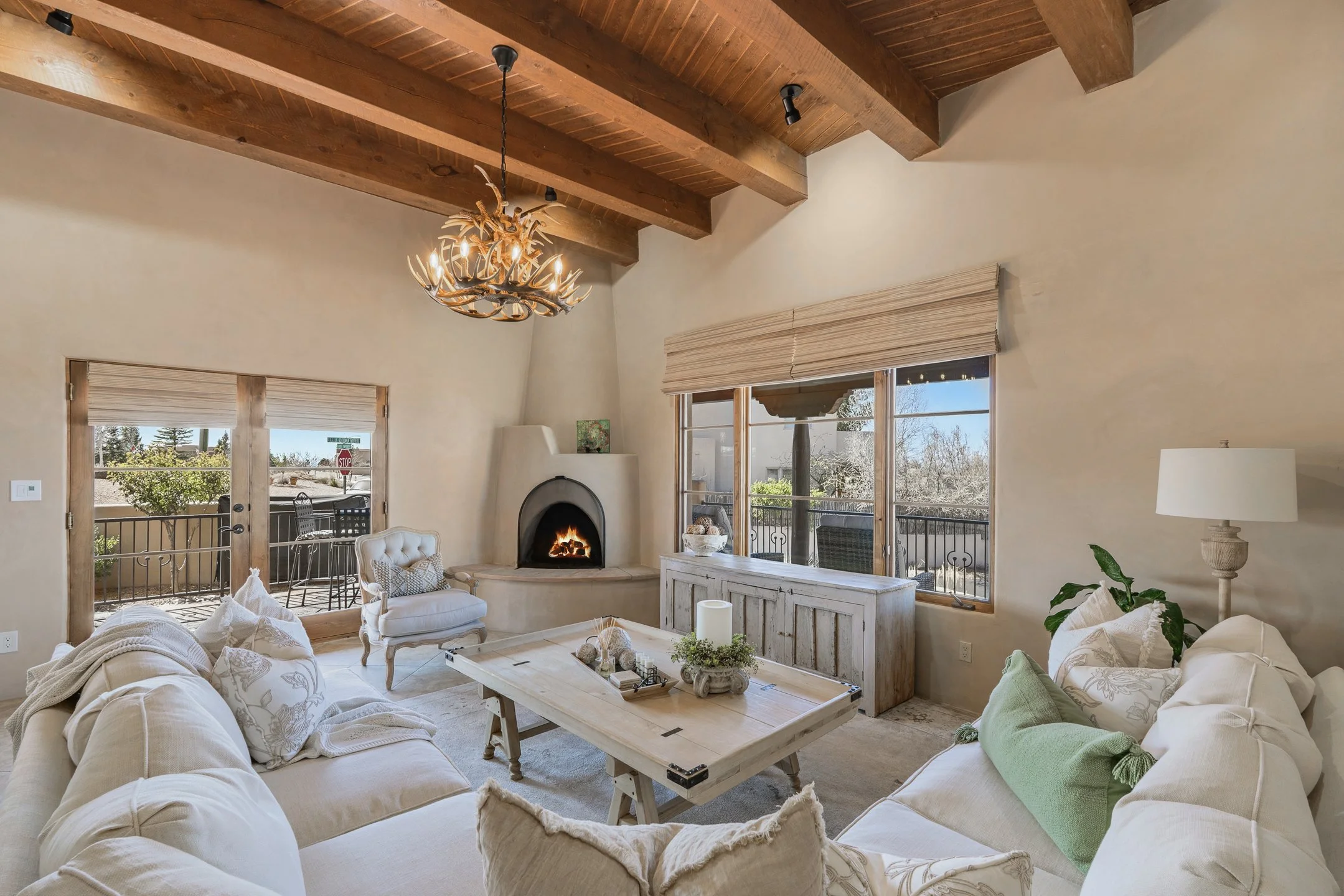 welcoming living room is anchored by a corner kiva fireplace