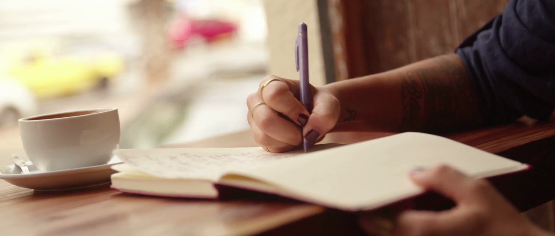 close-up-of-a-woman-writing-journal-in-coffee-shop_reljnvbml_thumbnail-full01.png
