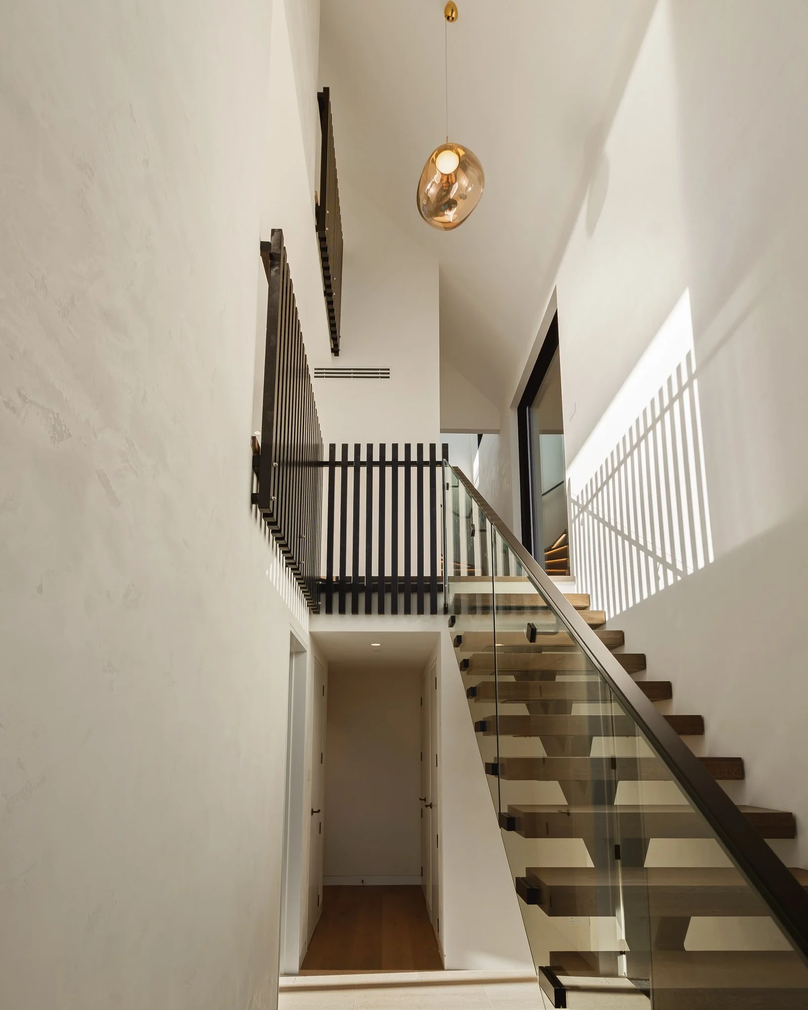 Westmere contemporary new build with floating stair case and interiors by Spatial Studio.