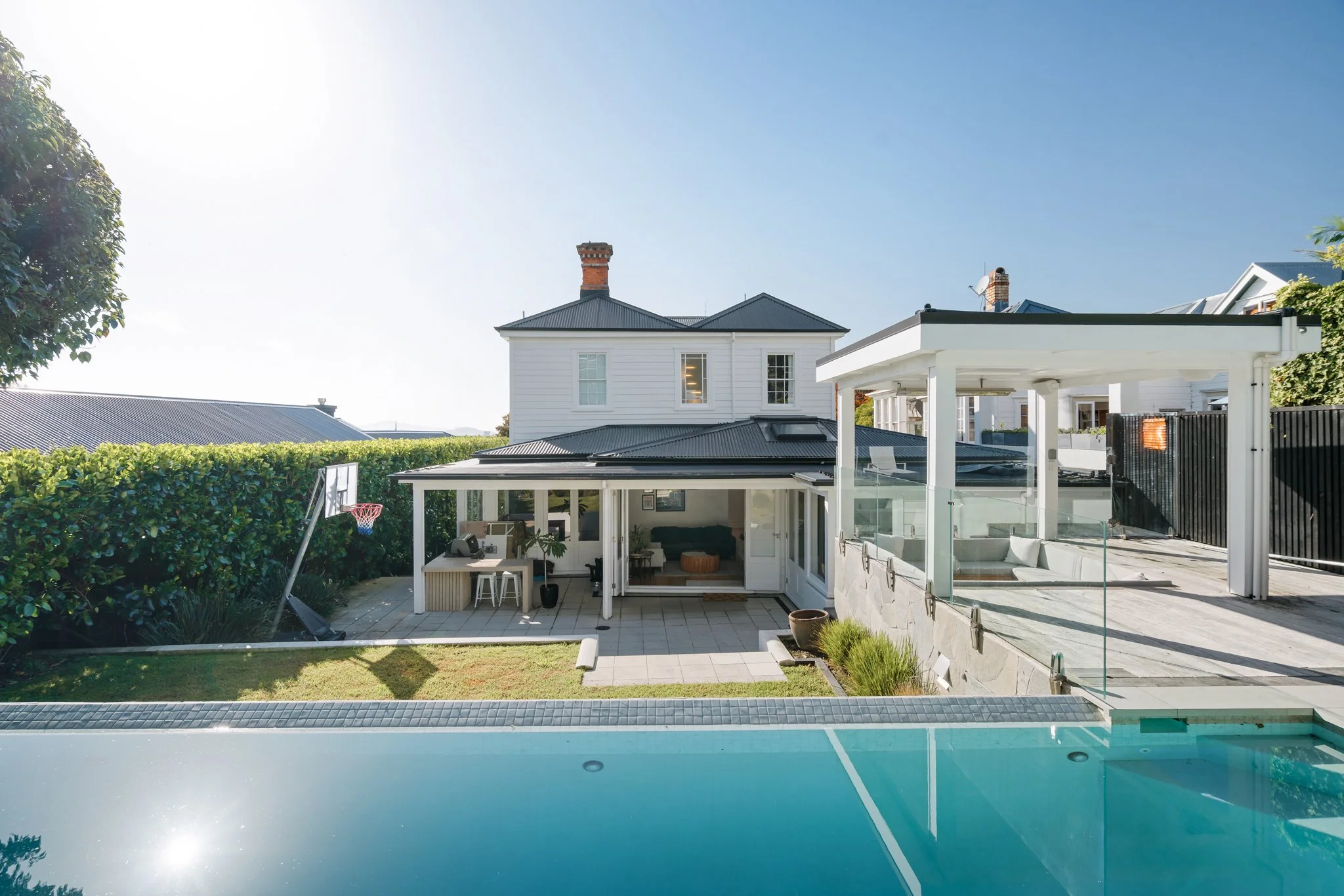 Freemans Bay double villa renovation rear garden — pool, spa pavilion, covered outdoor living and original villa by Macfie Architecture Auckland