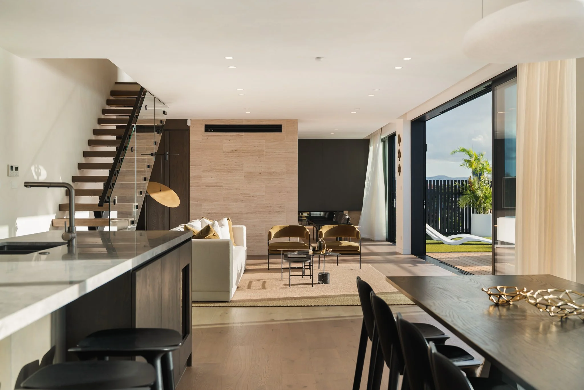 Floor to ceiling windows, hardwood floors, travertine feature wall and floating staircase.