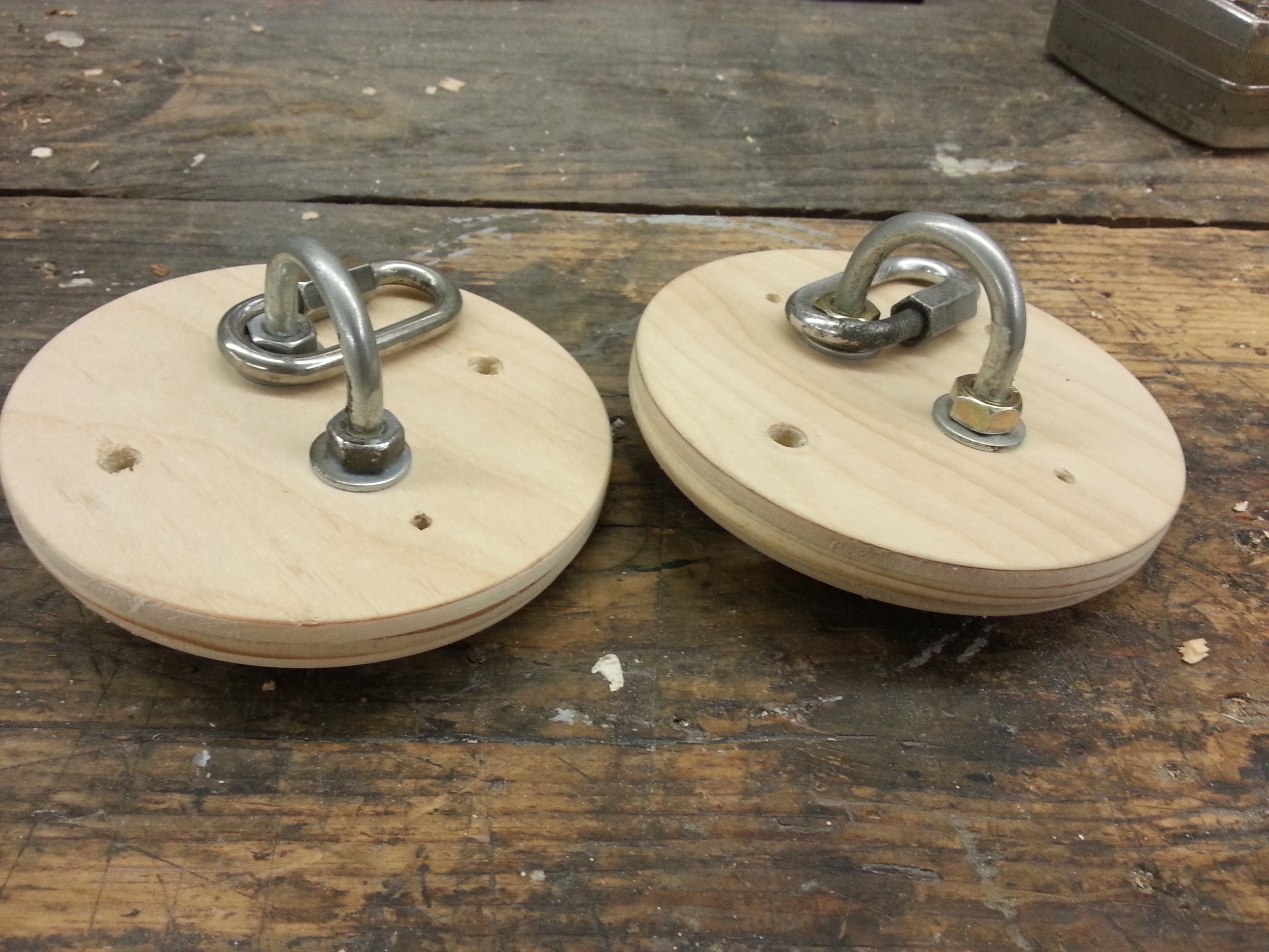 A pair of fresh bulkheads with the parachute attachment hardware installed. These are the ends of the electronics bay.