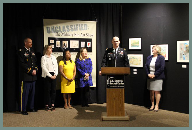 Garrison commander Col. Bill Marks talks about the exhibit "Unclassified: Military Kid Art Show" Thursday during its opening at the U.S. Space & Rocket Center. With him, from left, are Col. William Darby, commander of Fox Army Health Center; Marks' wife, Laurie; Linda Via, wife of Gen. Dennis Via, commander of the Army Materiel Command; exhibit co-curator Donna Musil and Dr. Deborah Barnhart, director of the U.S. Space & Rocket Center.