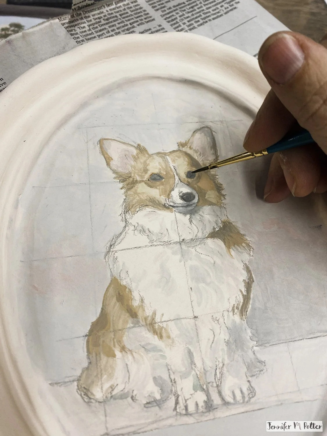 A ceramic painting in progress of a corgi.
