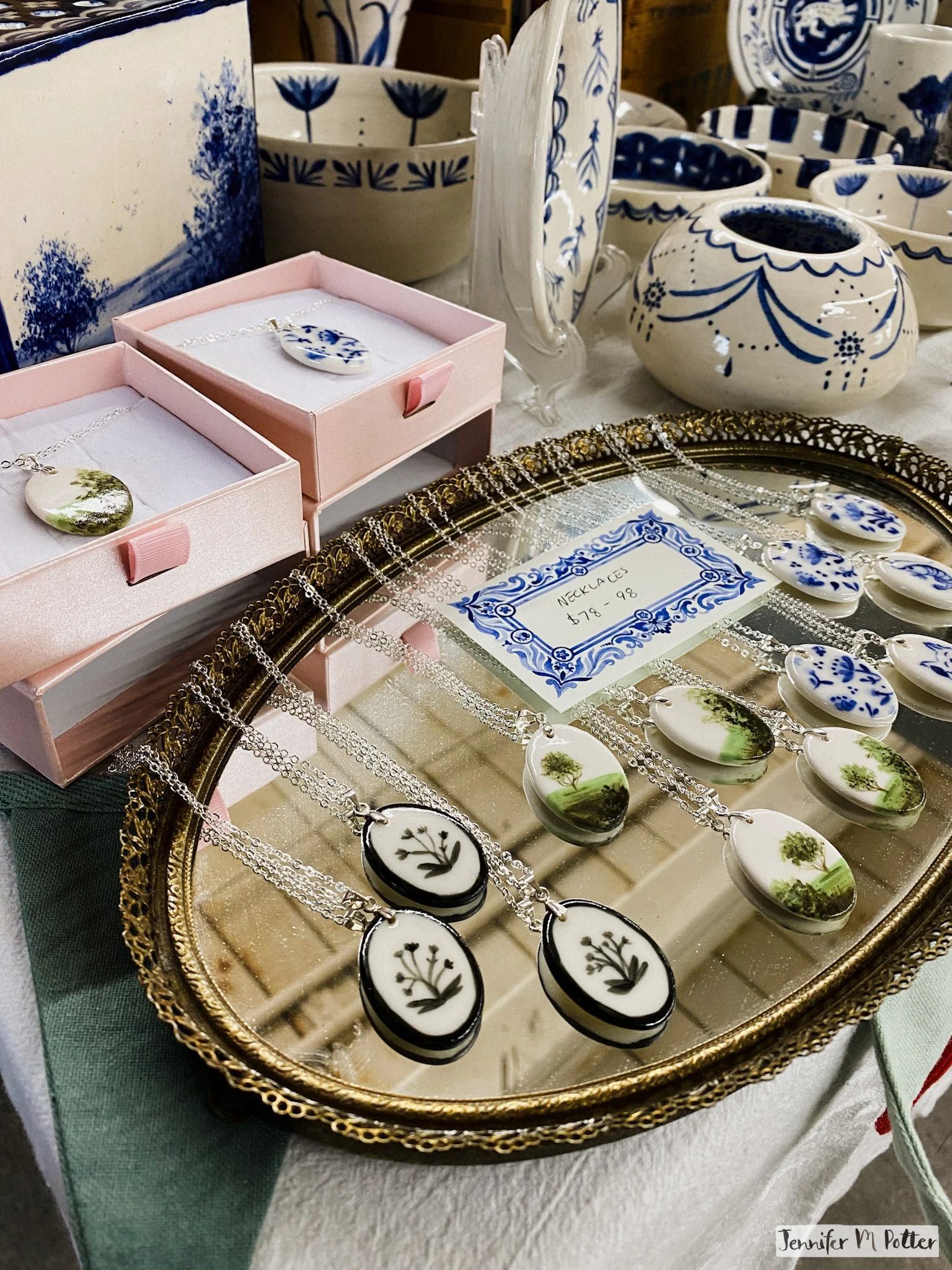 A display of hand-painted porcelain necklaces and other ceramics