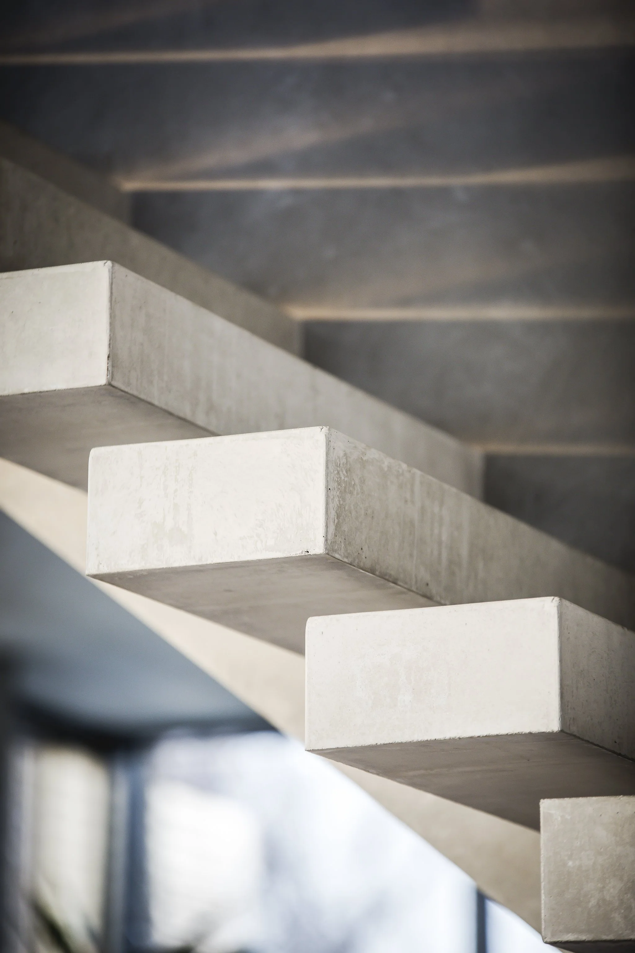 Close-up view of concrete staircase steps with natural light illuminating their sides.