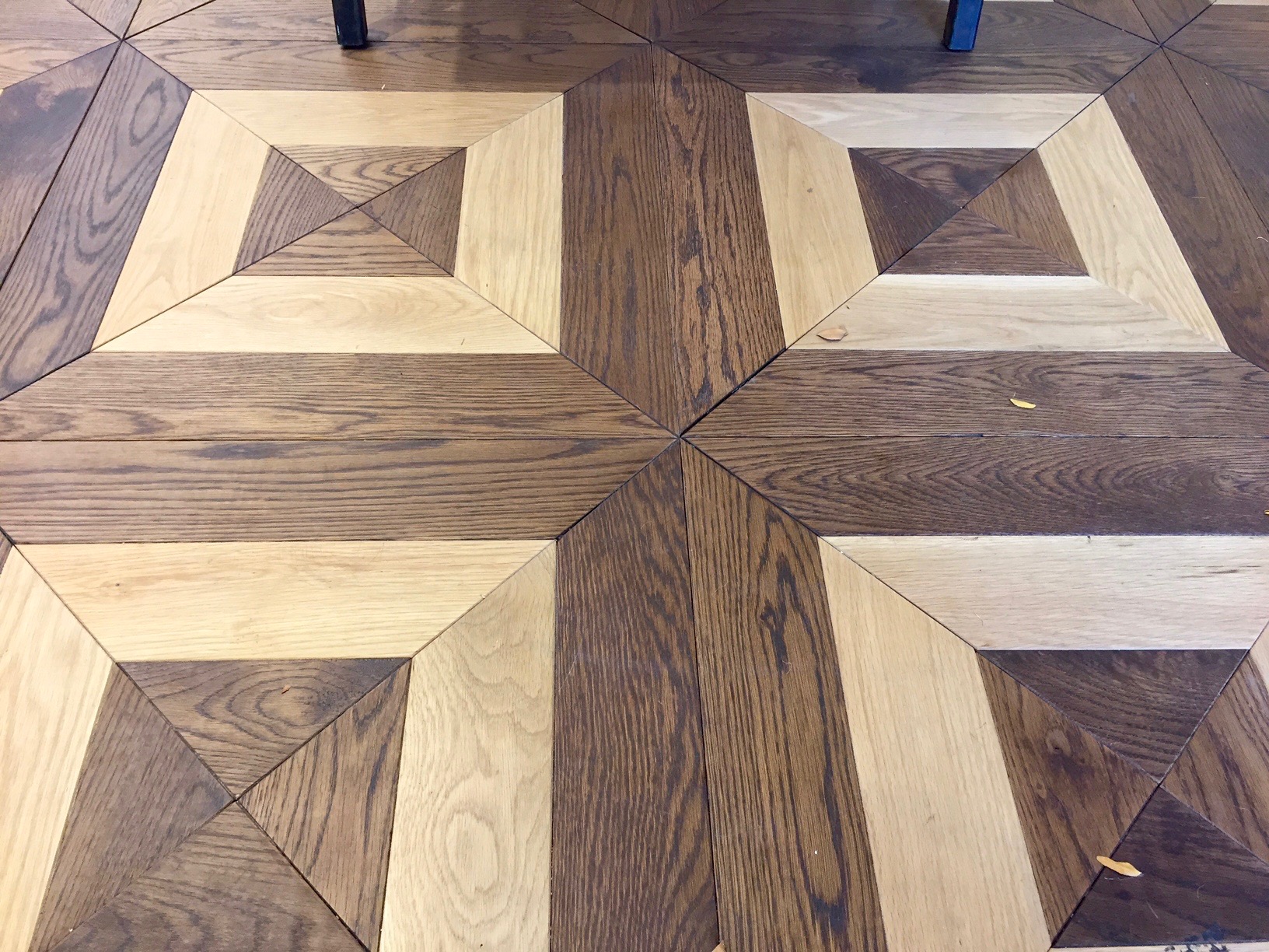 Detail of the store's custom White Oak parquet flooring design.