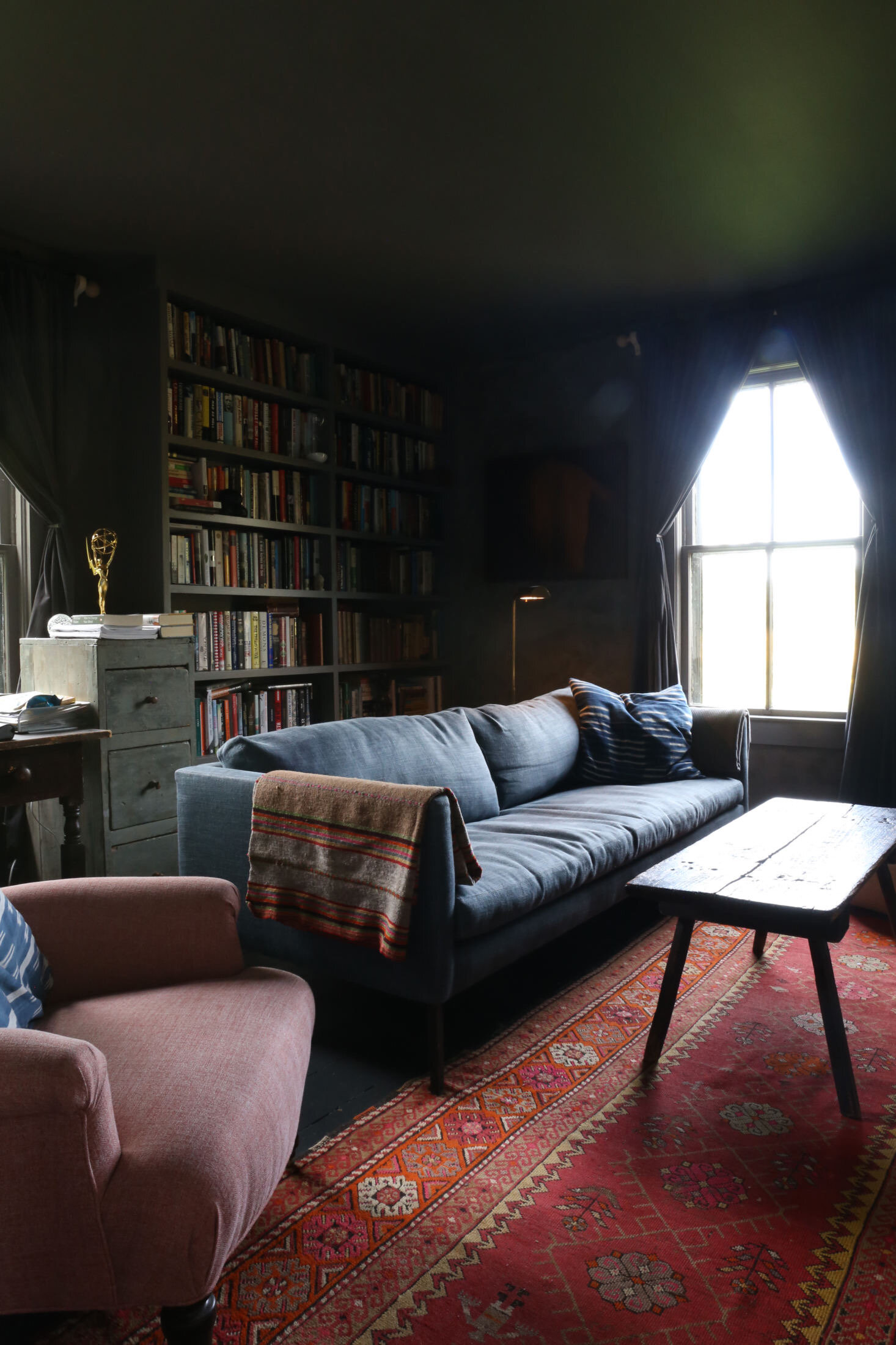 Above: The moody back room with new built-in bookshelves is the library/TV room and Corbin’s home office.