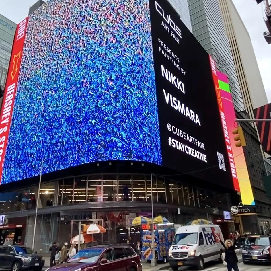 Photograph of Artist Nikki Vismara and her painting displayed on Times Square’s largest digital billboard in New York City