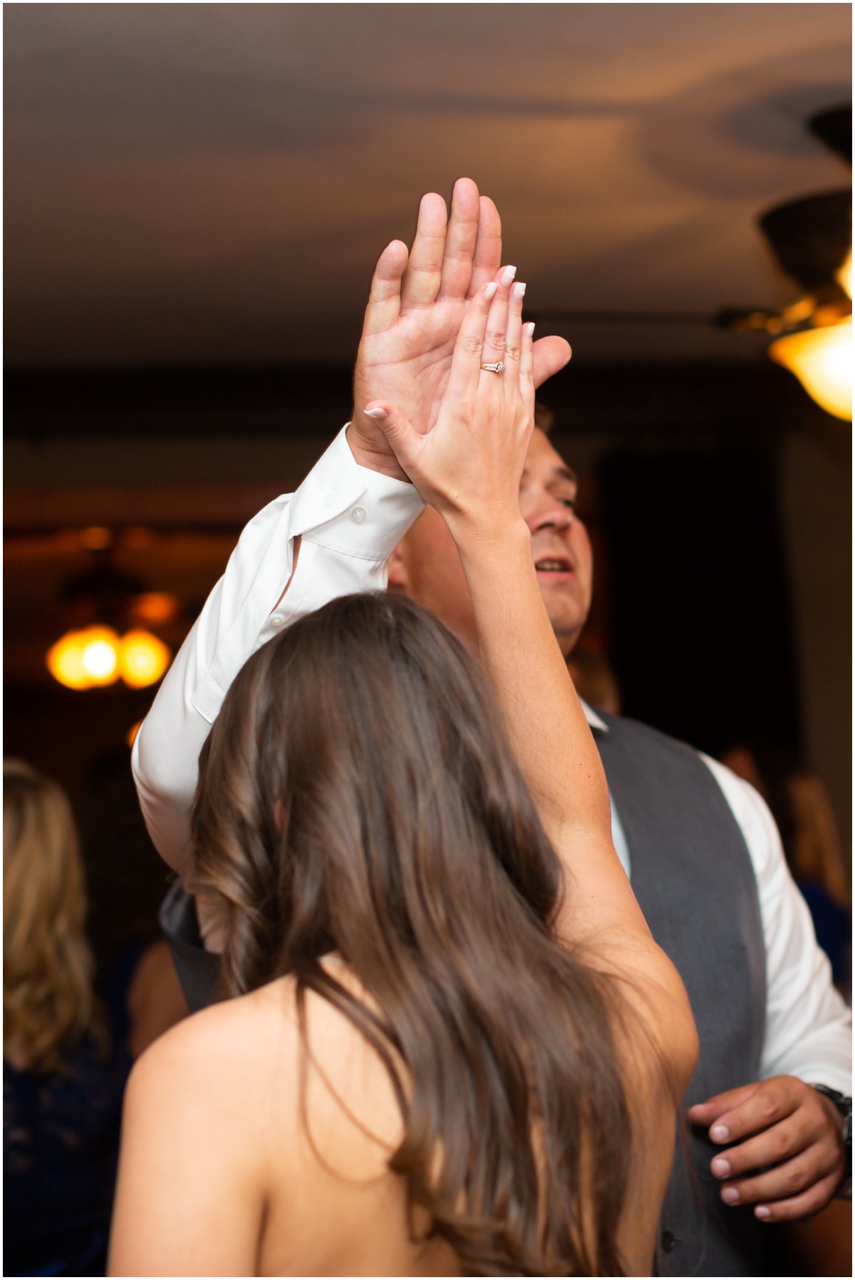 Katie high-fives one of the groomsmen on the dance floor.