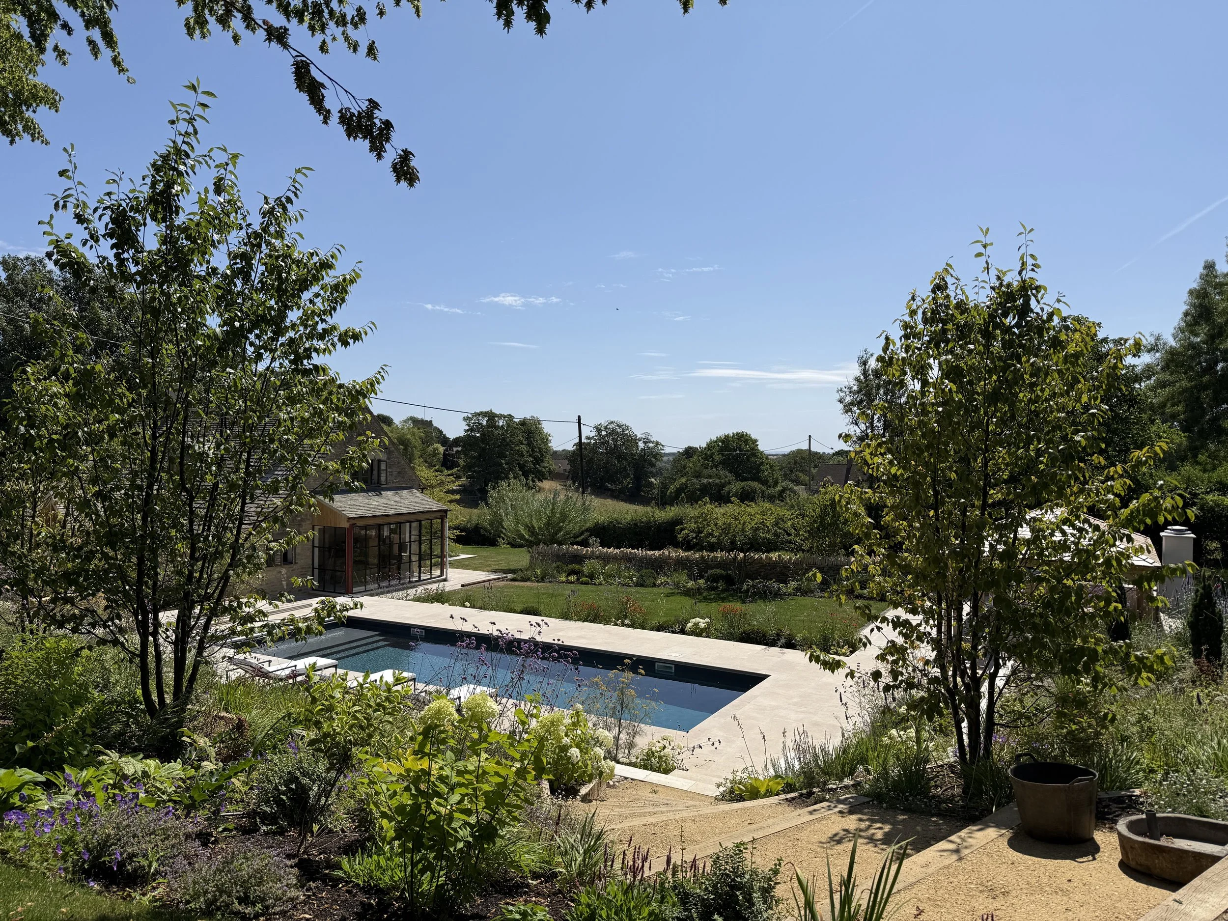 A spot to sit and relax looking over the pool and down the valley from the shade of the trees