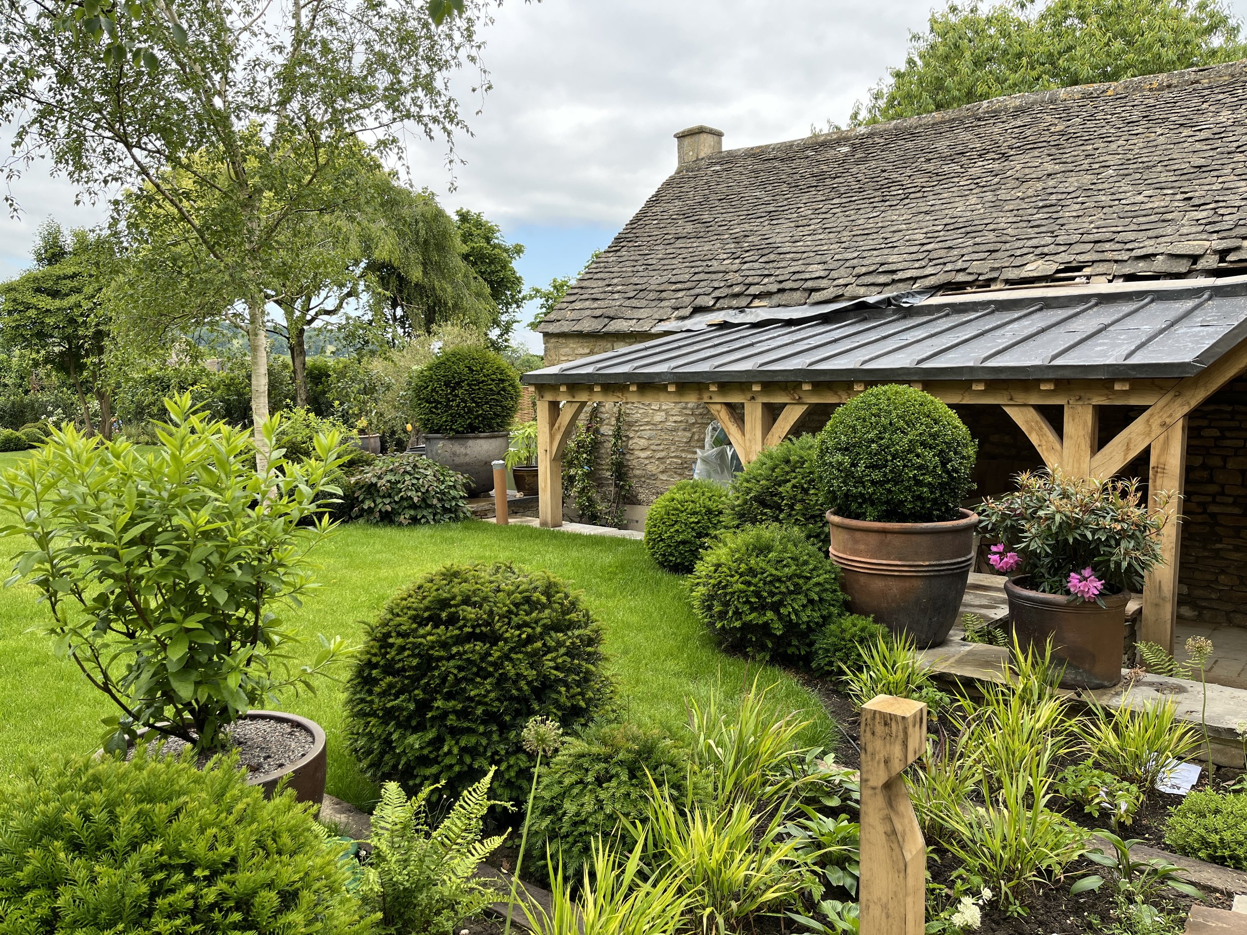 Topiary oak loggia entrance path cotswold garden 