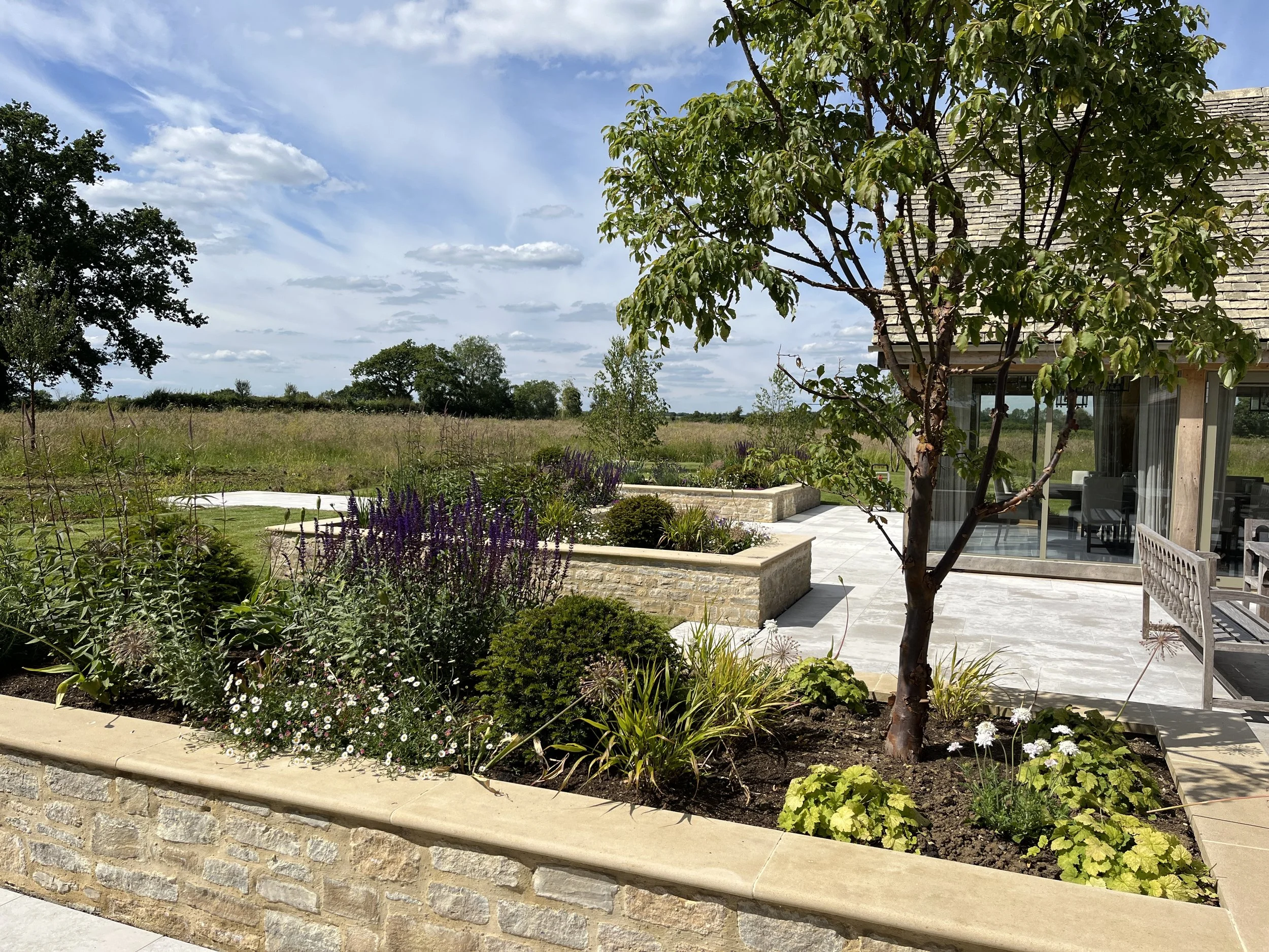 Formal dining terrace view out cotswold meadow avenue trees