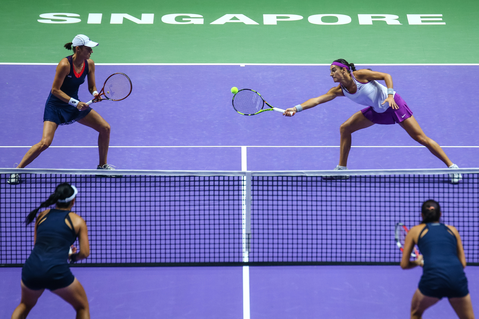 Caroline Garcia of France and Katarina Srebotnik of Slovenia in action against Chan Hao-Ching and Chan Yung-Jan of Chinese Taipei during their doubles match during the BNP Paribas WTA Finals at the OCBC Arena on October 26, 2015 in Singapore.