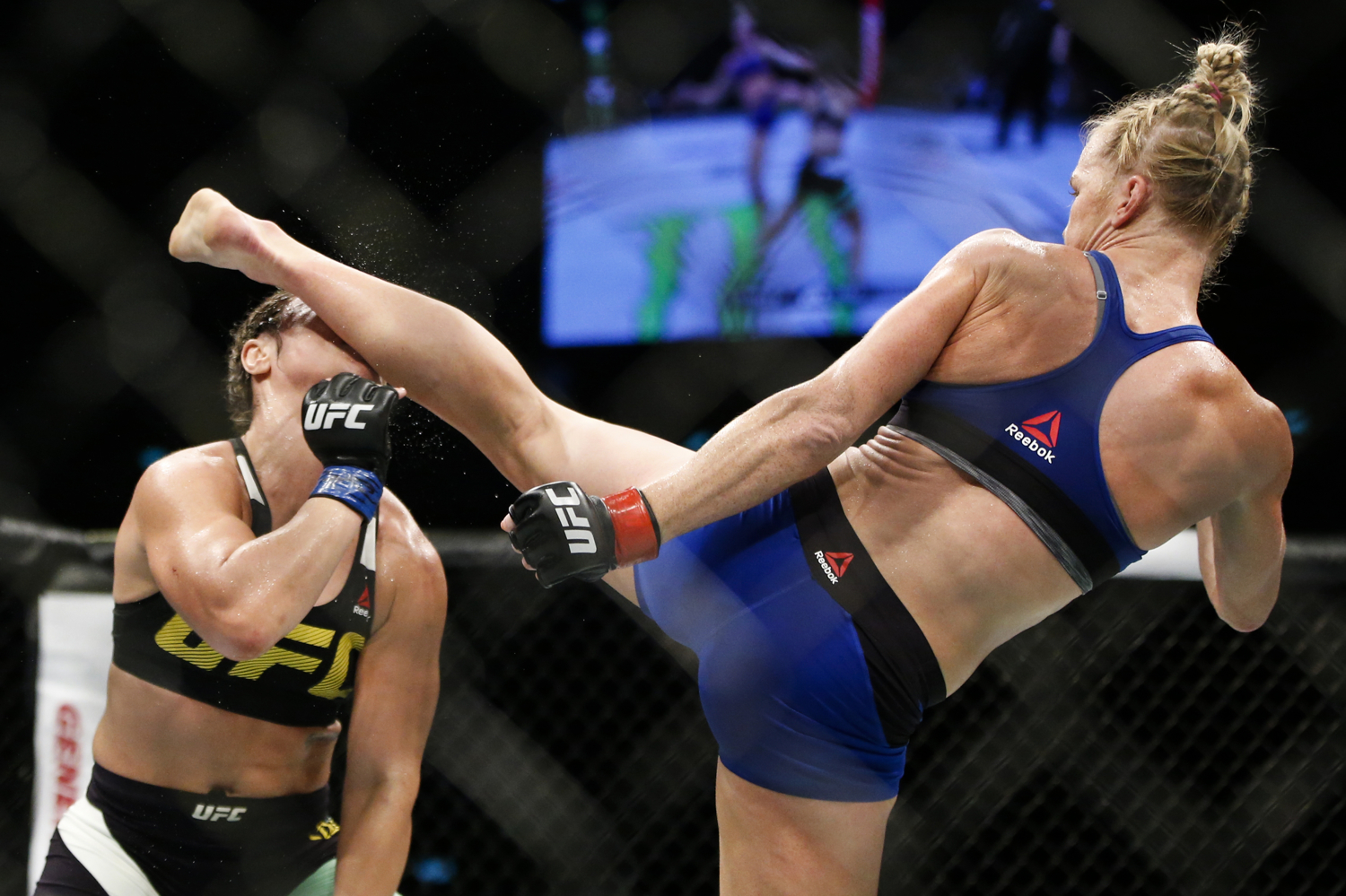  Holly Holm (R) of the United States knocks out Bethe Correia of Brazil with a kick during their bantamweight bout at the UFC Fight Night at the Singapore Indoor Stadium on June 17, 2017. 