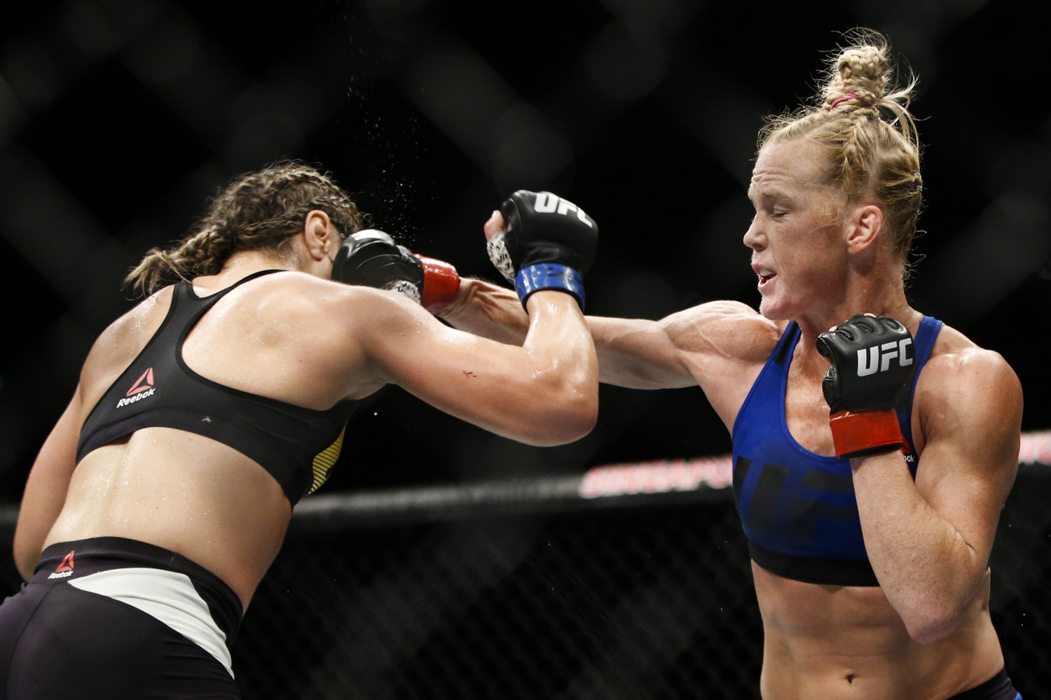  Holly Holm (R) of the United States punches Bethe Correia of Brazil during their bantamweight bout at the UFC Fight Night at the Singapore Indoor Stadium on June 17, 2017. 