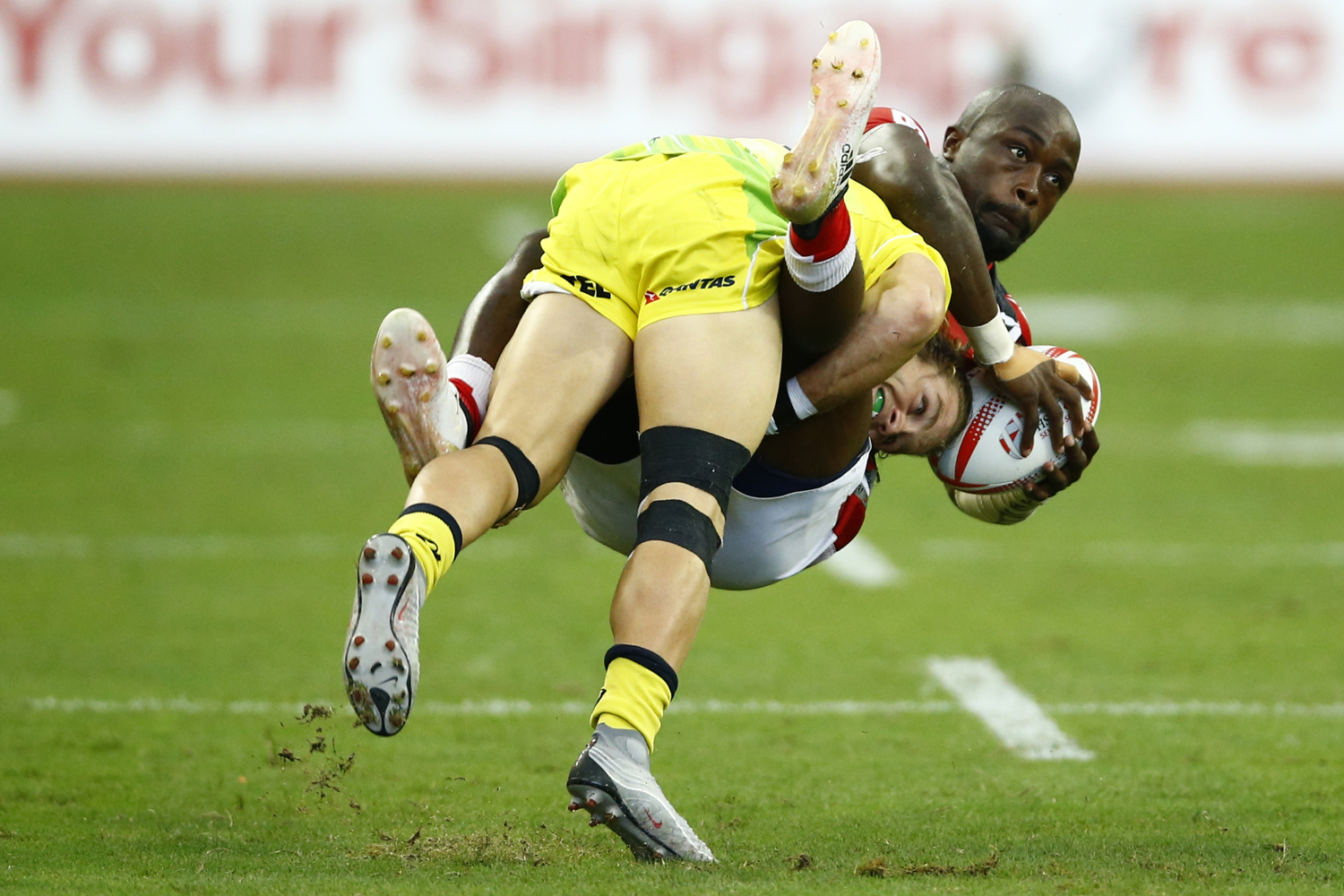  Rugby Union - Singapore Sevens - National Stadium, Singapore, 15/04/17 - Kenya's Frank Wanyama is tackled by Australia's Tom Lucas. REUTERS/Yong Teck Lim 
