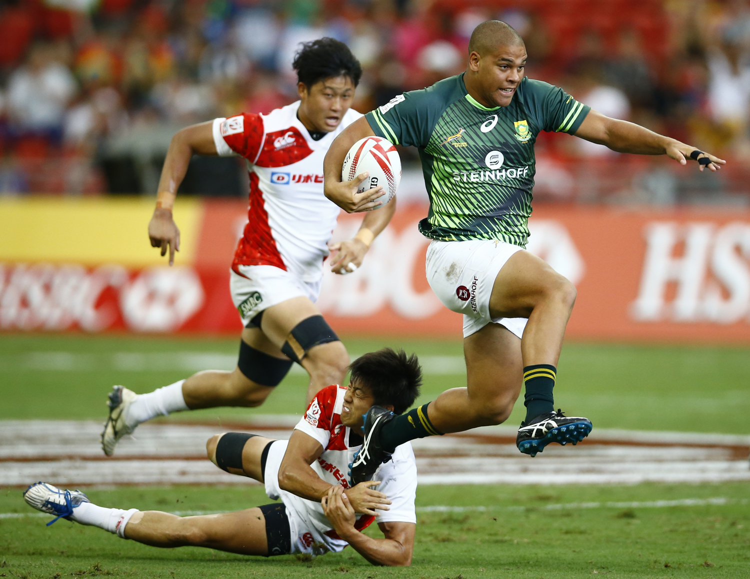  Rugby Union - Singapore Sevens - National Stadium, Singapore, 15/04/17 - South Africa's Zain Davids (R) tries to evade a tackle by Japan's Kosuke Hashino. REUTERS/Yong Teck Lim 