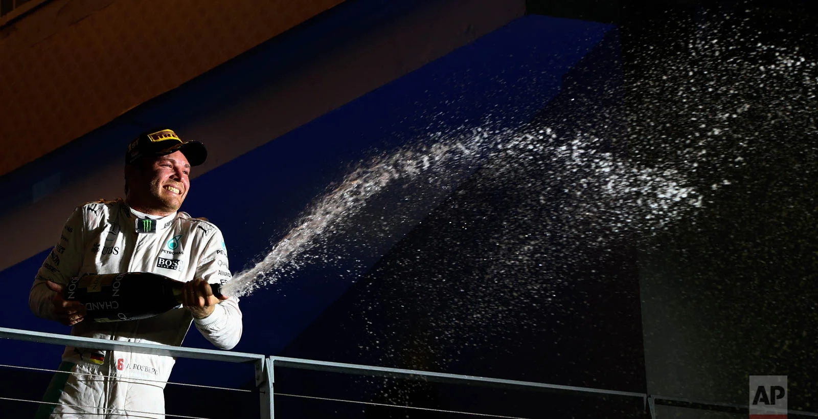Mercedes driver Nico Rosberg of Germany sprays champagne as he celebrates after winning the Singapore Formula One Grand Prix on the Marina Bay City Circuit in Singapore, Sunday, Sept. 18, 2016. (AP Photo/Yong Teck Lim)