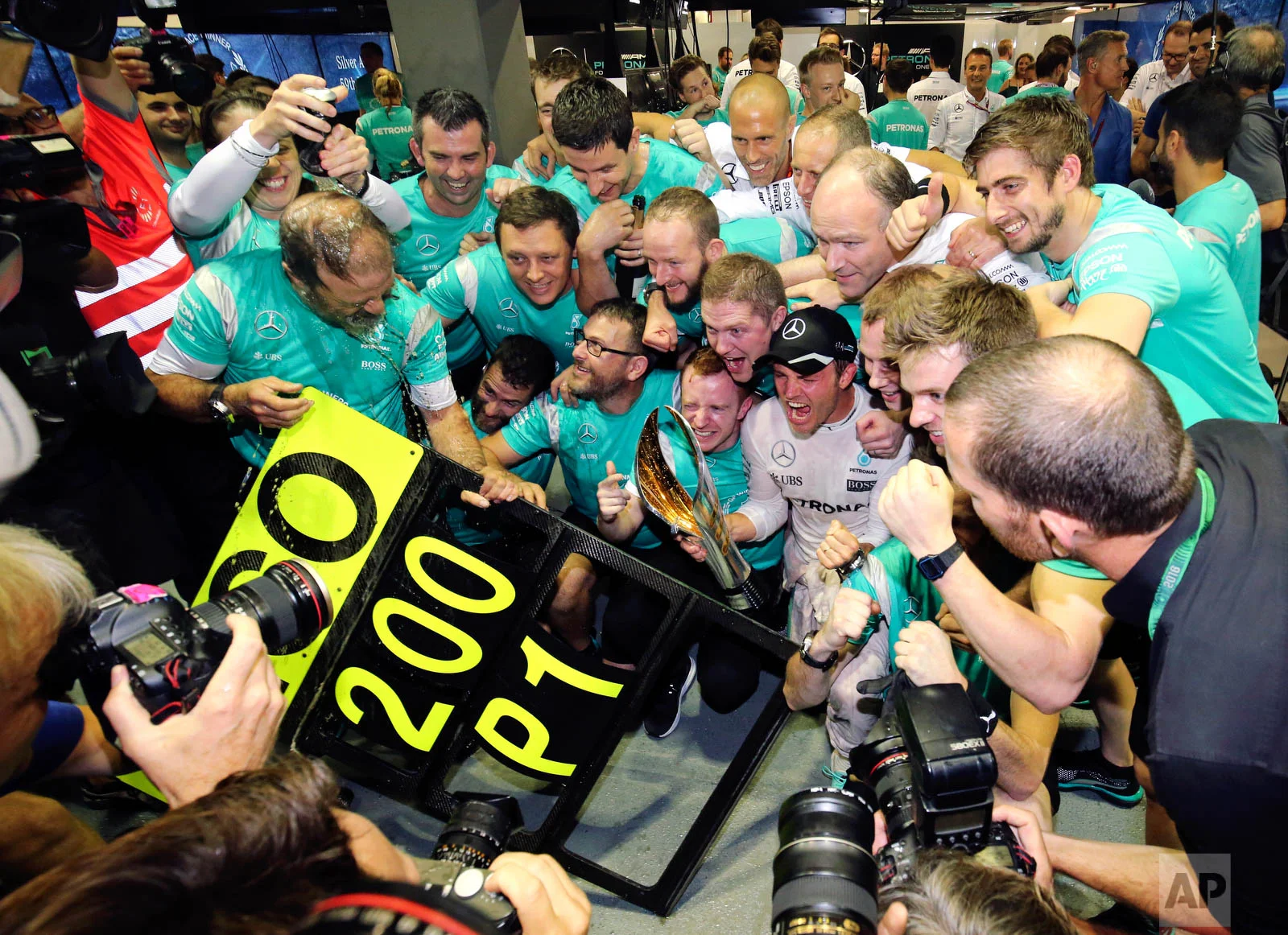 Mercedes driver Nico Rosberg of Germany celebrates with his team after winning the Singapore Formula One Grand Prix on the Marina Bay City Circuit Singapore, Sunday, Sept. 18, 2016. (AP Photo/Yong Teck Lim)