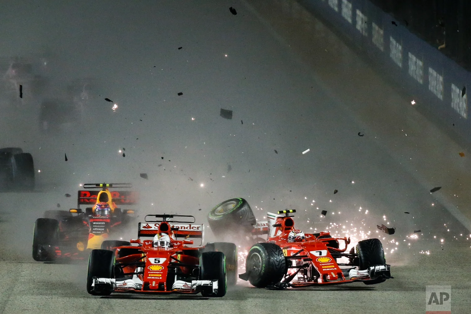 Ferrari driver Kimi Raikkonen, right, of Finland collides with teammate Sebastian Vettel of Germany at the start of the Singapore Formula One Grand Prix on the Marina Bay City Circuit Singapore, Sunday, Sept. 17, 2017. (AP Photo/Yong Teck Lim)
