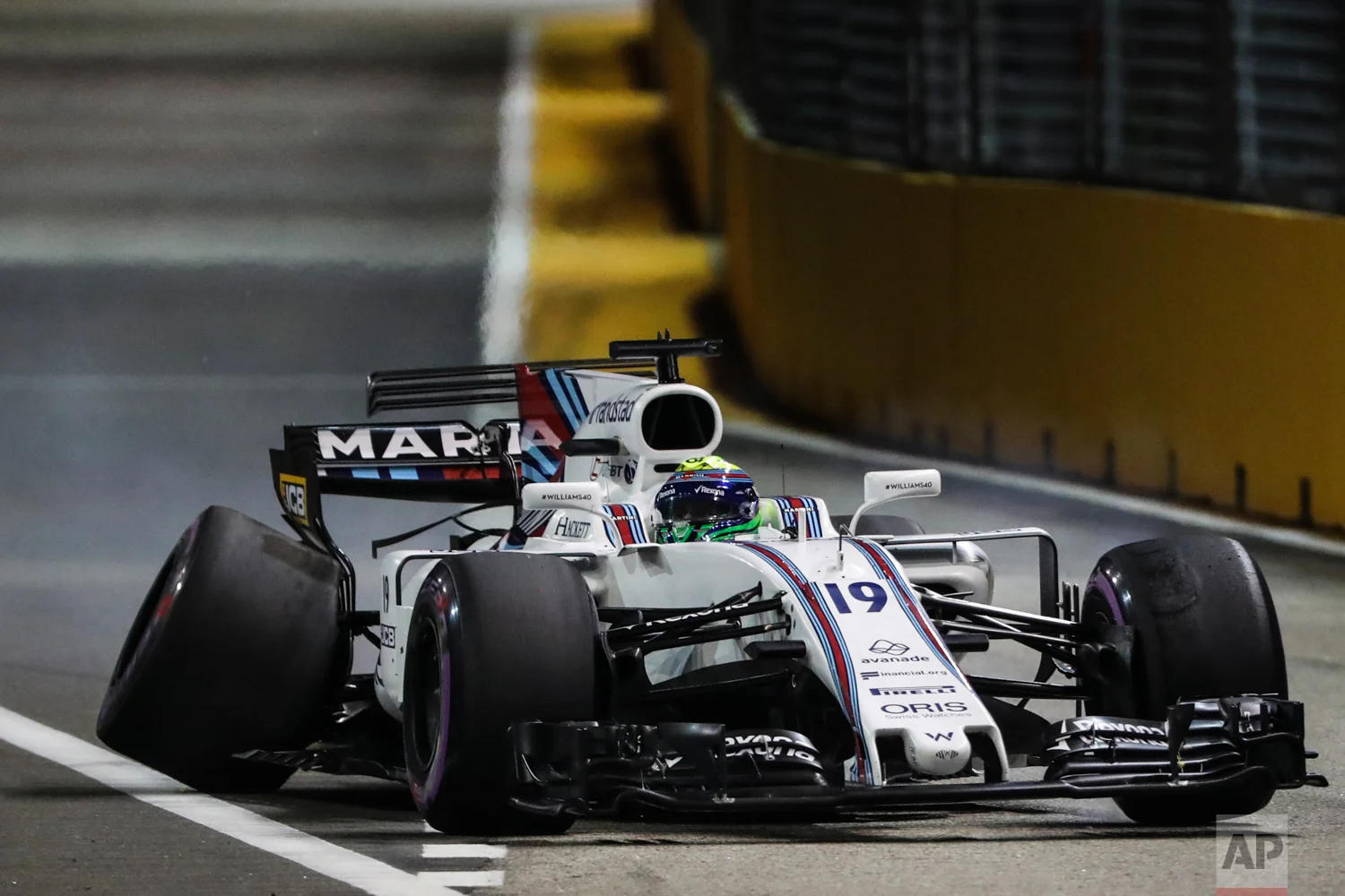 Williams driver Felipe Massa of Brazil steers his car with the rear wheel damaged after hitting the wall during the qualifying session for the Singapore Formula One Grand Prix on the Marina Bay City Circuit Singapore, Saturday, Sept. 16, 2017. (AP Photo/Yong Teck Lim)