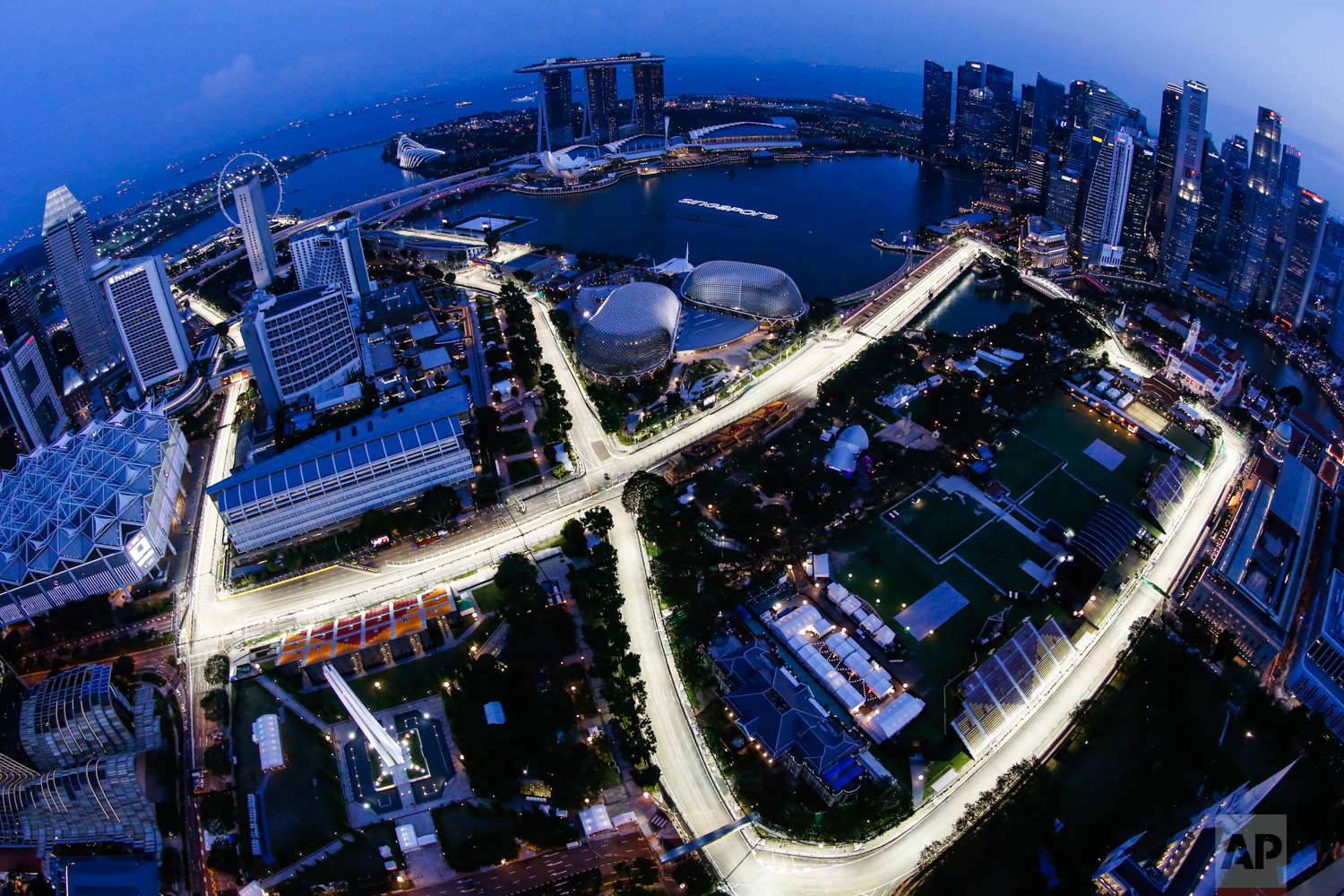  In this image made with a fisheye lens from the Swissotel The Stamford, the Singapore F1 Grand Prix's Marina Bay City Circuit is lit at dusk in Singapore on Thursday, Sept. 14, 2017. (AP Photo/Yong Teck Lim) 