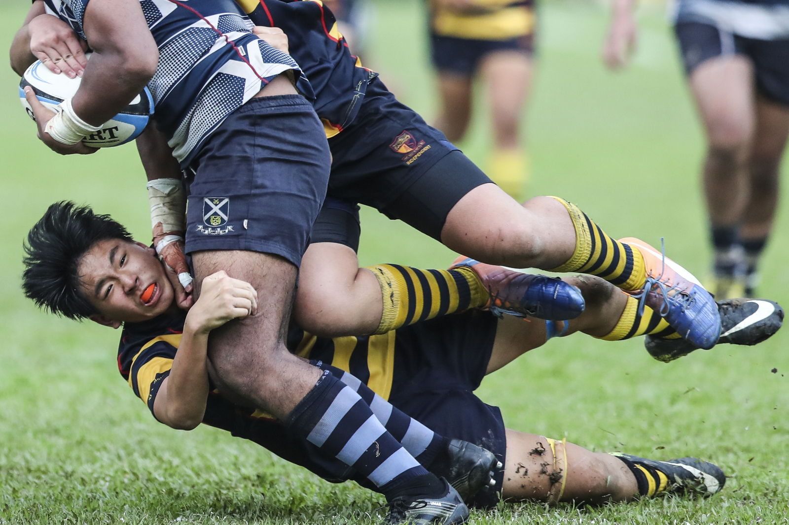 Iain Yeow of Anglo-Chinese School (Independent) falls after a tackle on Umar Mohamed Sha’ari of St. Andrew’s Secondary School during the National Schools boys’ ‘B’ Division rugby final at Queenstown Stadium on March 28, 2018 in Singapore. (Photo © Yong Teck Lim/Red Sports)