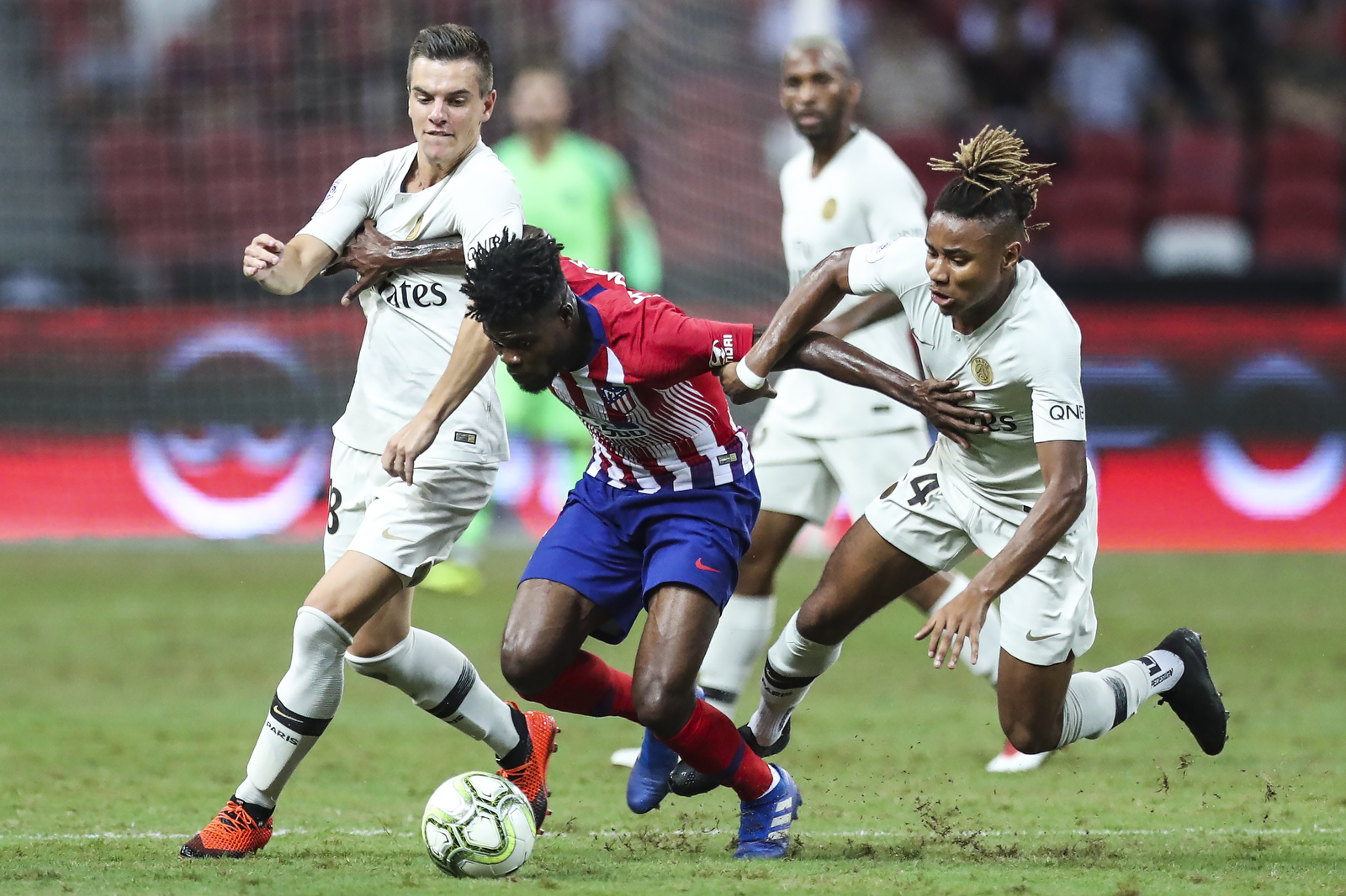 Atletico Madrid’s Thomas Partey, center, controls the ball against Paris Saint-Germain’s Giovani Lo Celso, left, and Christopher Nkunku  during the International Champions Cup match between Paris Saint-Germain and Atletico Madrid in Singapore, Monda