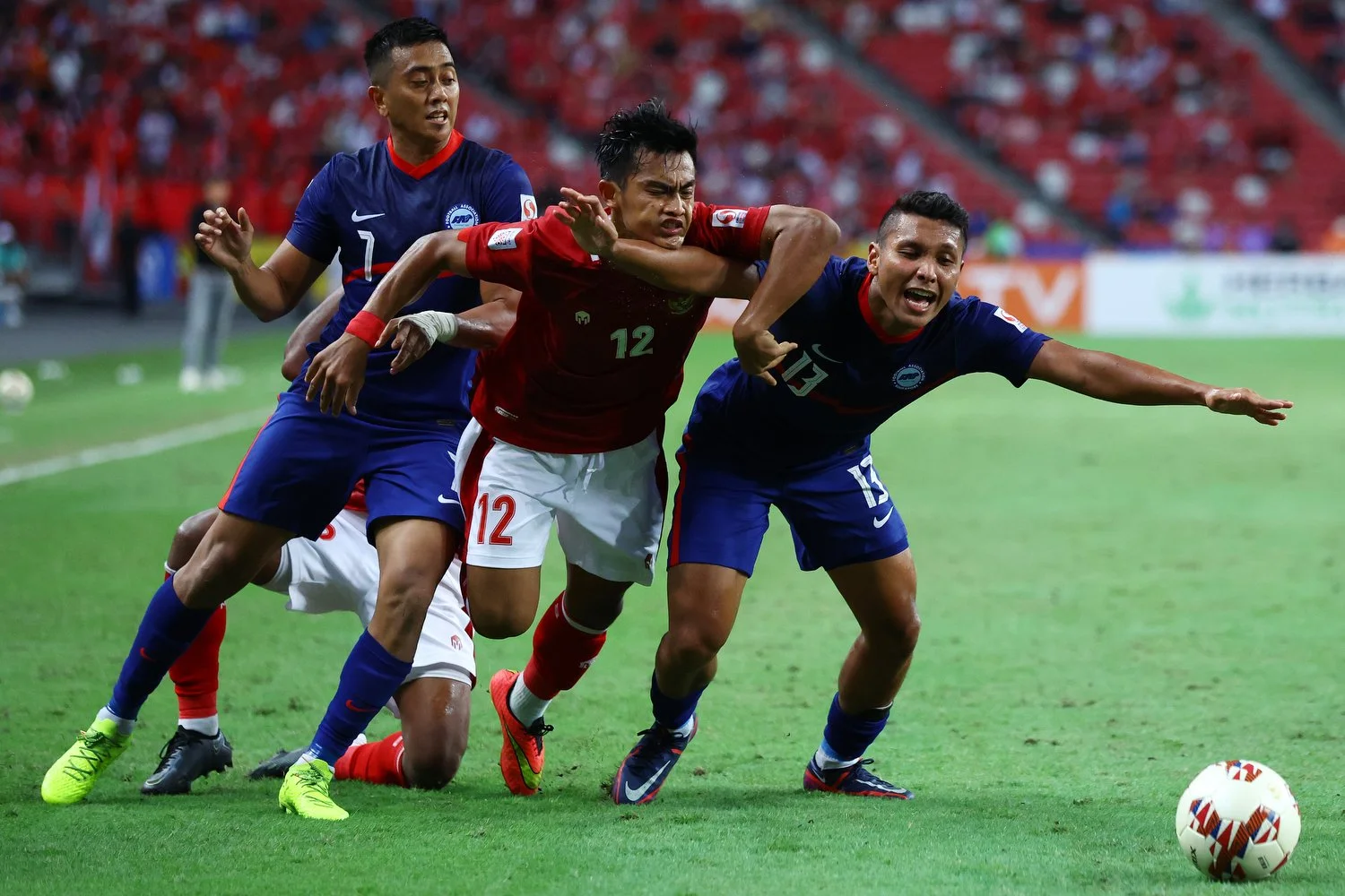  SINGAPORE, SINGAPORE - DECEMBER 25: Pratama Arhan Alif Rifai #12 of Indonesia competes for the ball against Amy Recha #7 and Zulqarnaen Suzliman #13 of Singapore in the first half during the second leg of their AFF Suzuki Cup semifinal at the Nation
