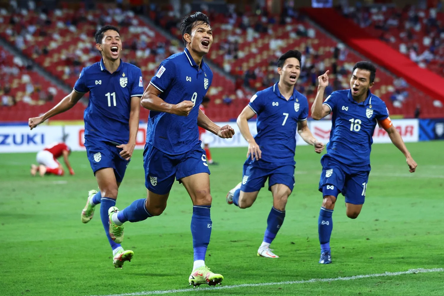 SINGAPORE, SINGAPORE - JANUARY 01: Adisak Kraisorn #9 of Thailand celebrates with his teammates after scoring their first goal against Indonesia in the second half during the second leg of the AFF Suzuki Cup final at the National Stadium on January 