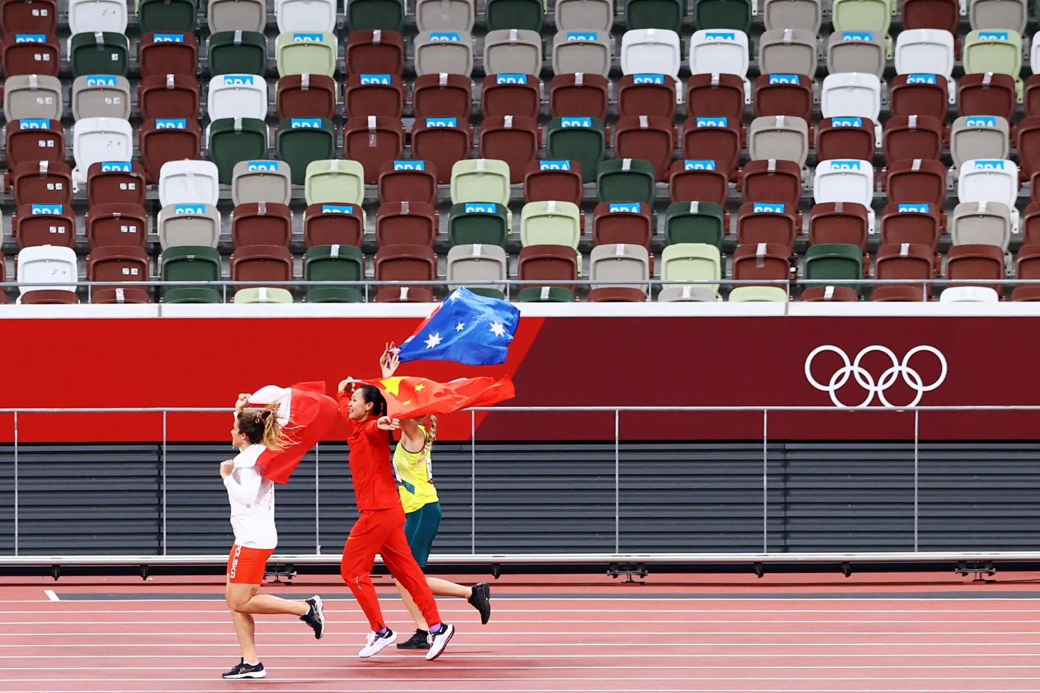  TOKYO, JAPAN - AUGUST 06: Silver medalist Maria Andrejczyk of Team Poland, gold medalist Shiying Liu of Team China and bronze medalist Kelsey-Lee Barber of Team Australia celebrate after the Women's Javelin Throw Final on day fourteen of the Tokyo 2