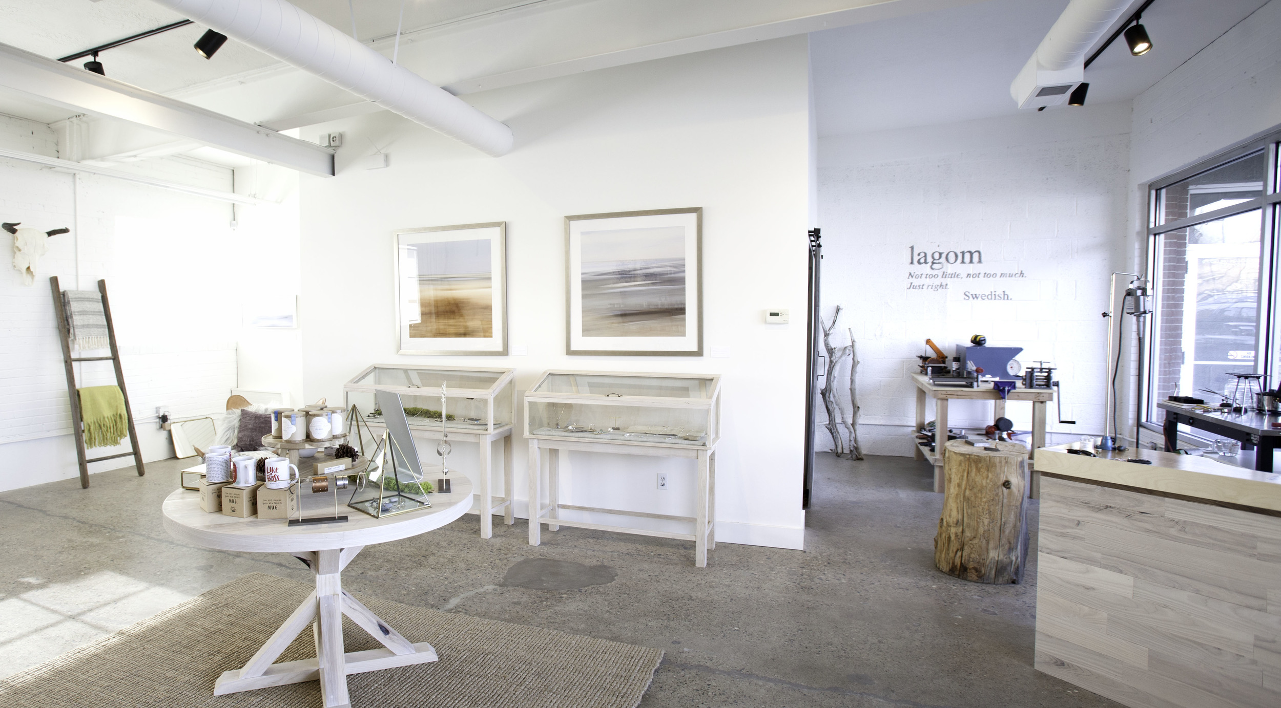 And here's a view of the finished space. My silversmithing desk to the right, my stump where I hammer, the torching station by the window and my workbench with tools. In the middle, the custom-built display cases and table, my abstract photography on the walls. 