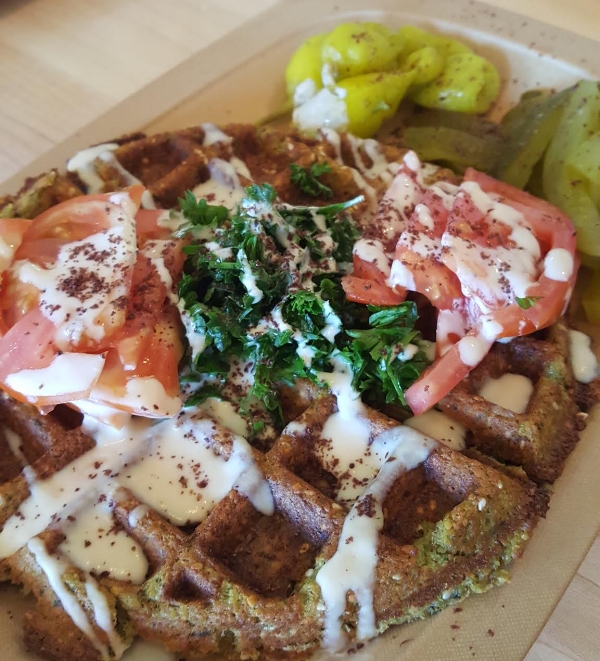 Chickpea's Fawaffle topped with tahini, fresh parsley, tomatoes, and paired with pickled peppers. Pure genius!