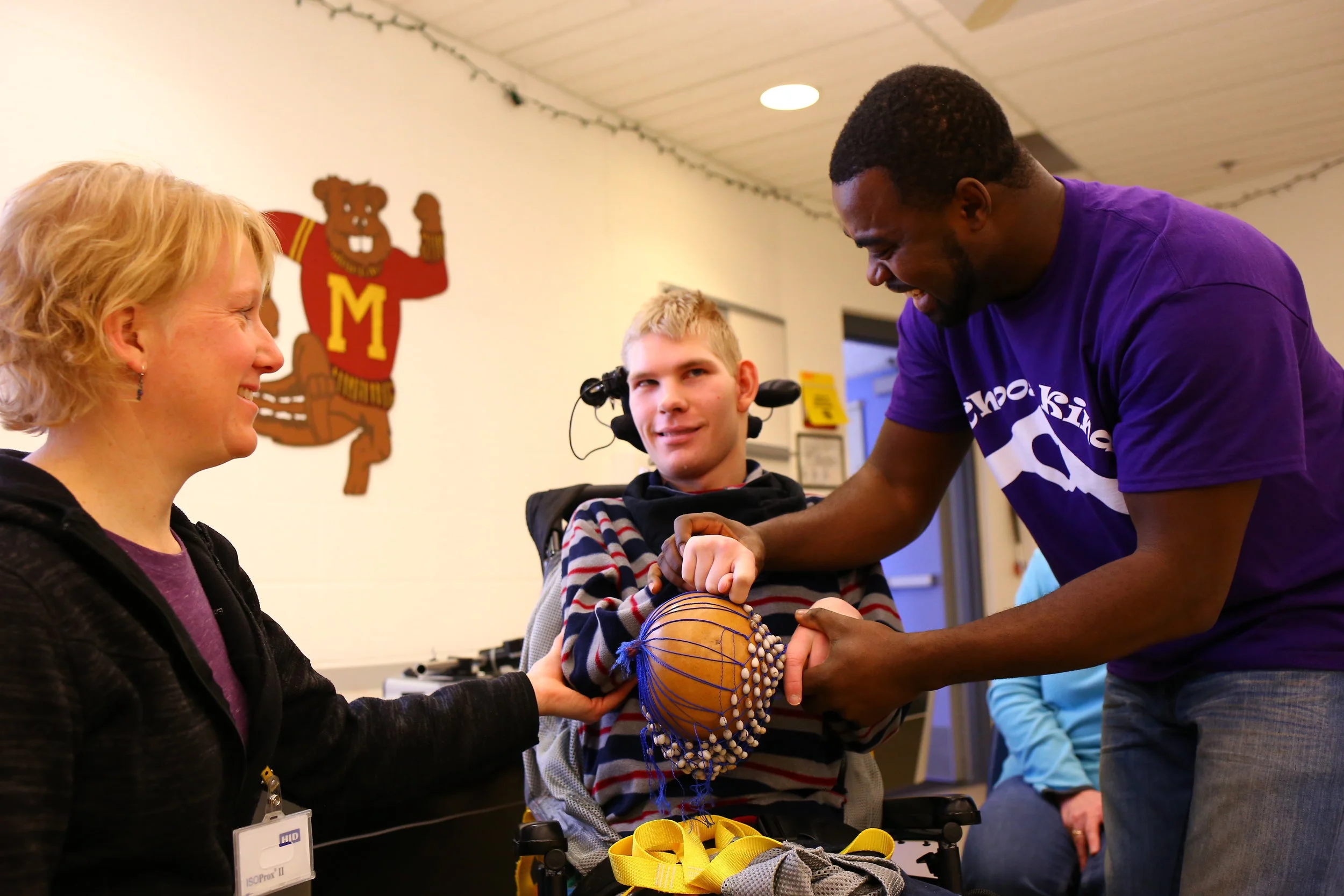 A teacher at the Minnesota School for the Blind works with COMPAS artist Christian Adeti and a student during a West African drumming workshop