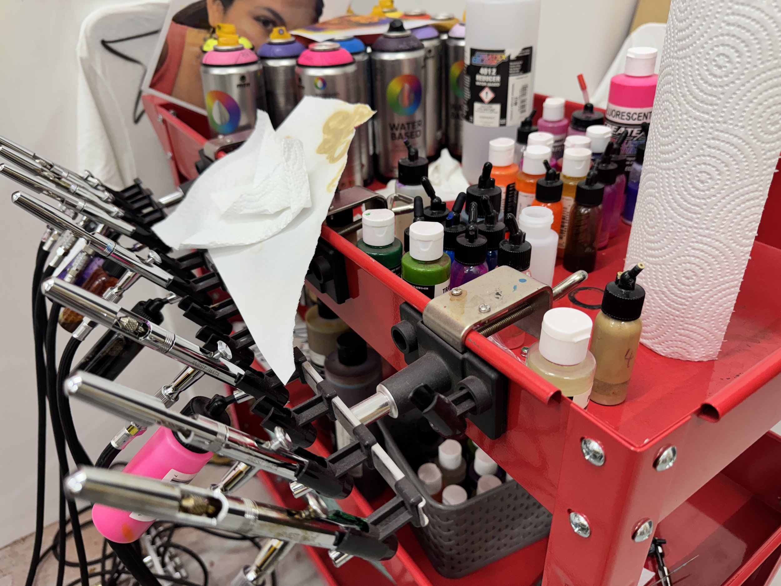 photo of red mobile cart with airbrushes and spray paints